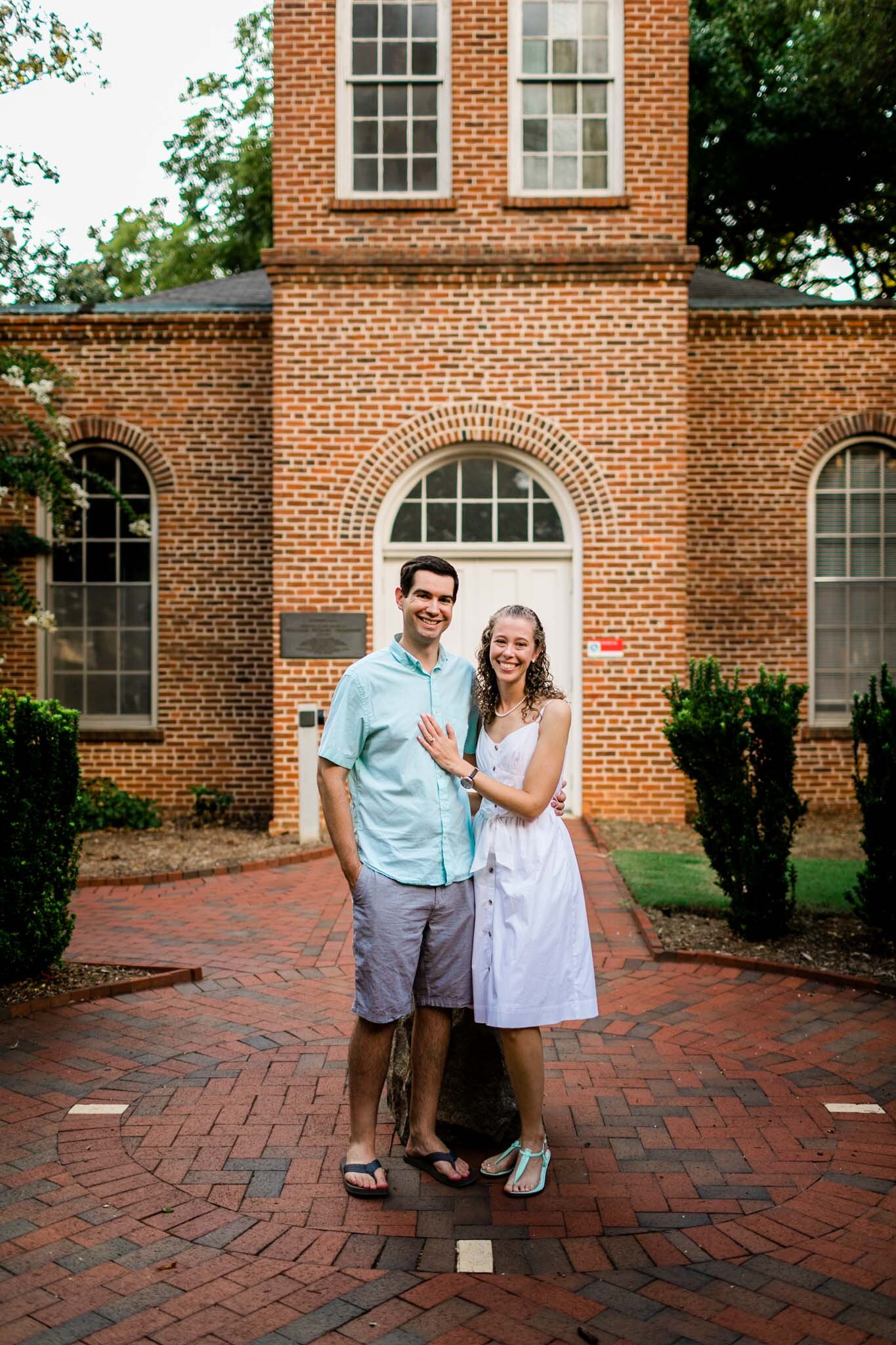 Raleigh Engagement Photographer | NC State | By G. Lin Photography | Couple taking photo in front of Primrose Hall