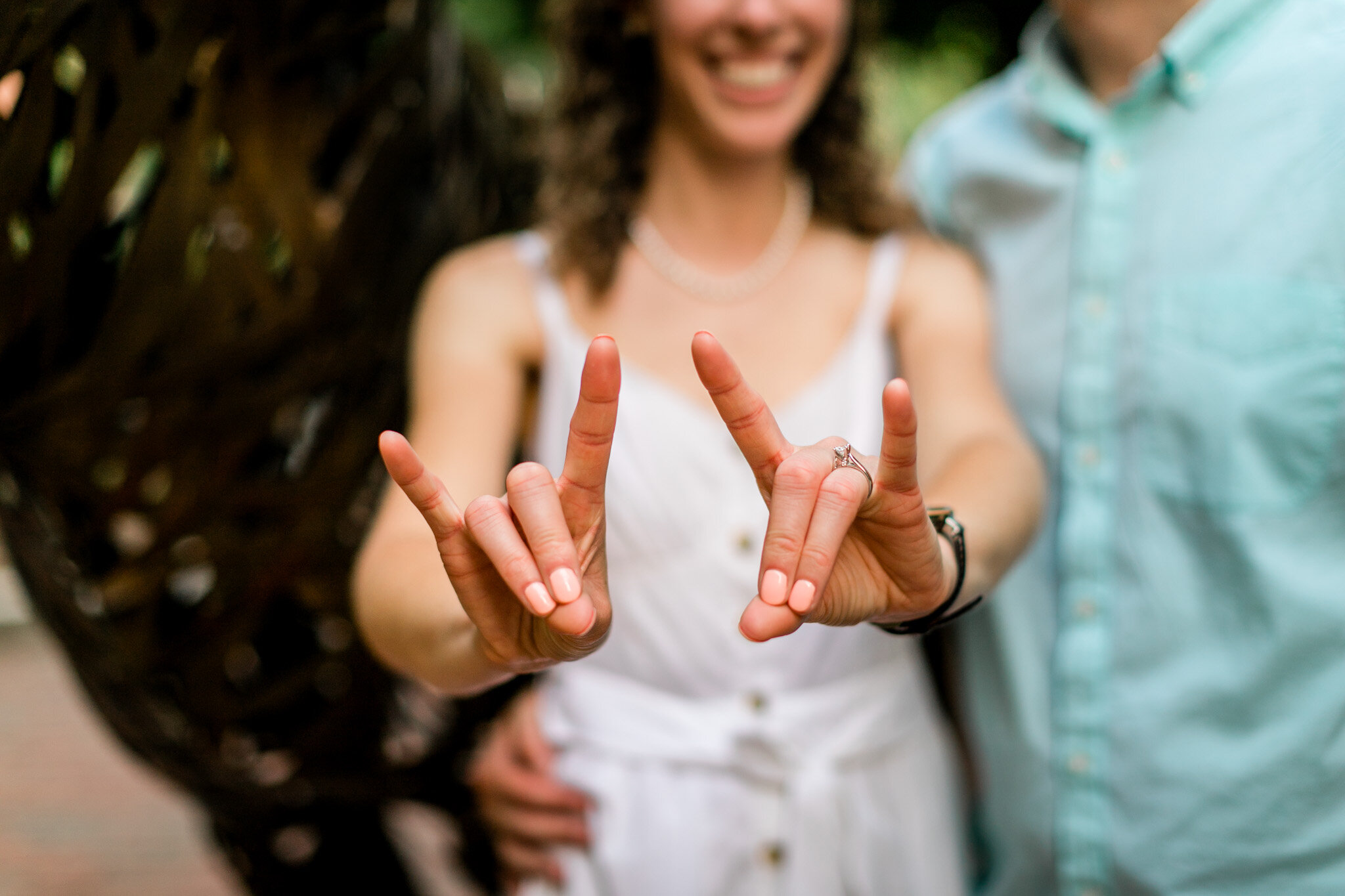 Raleigh Engagement Photographer | NC State University | By G. Lin Photography | Woman making Wolfpack hand sign