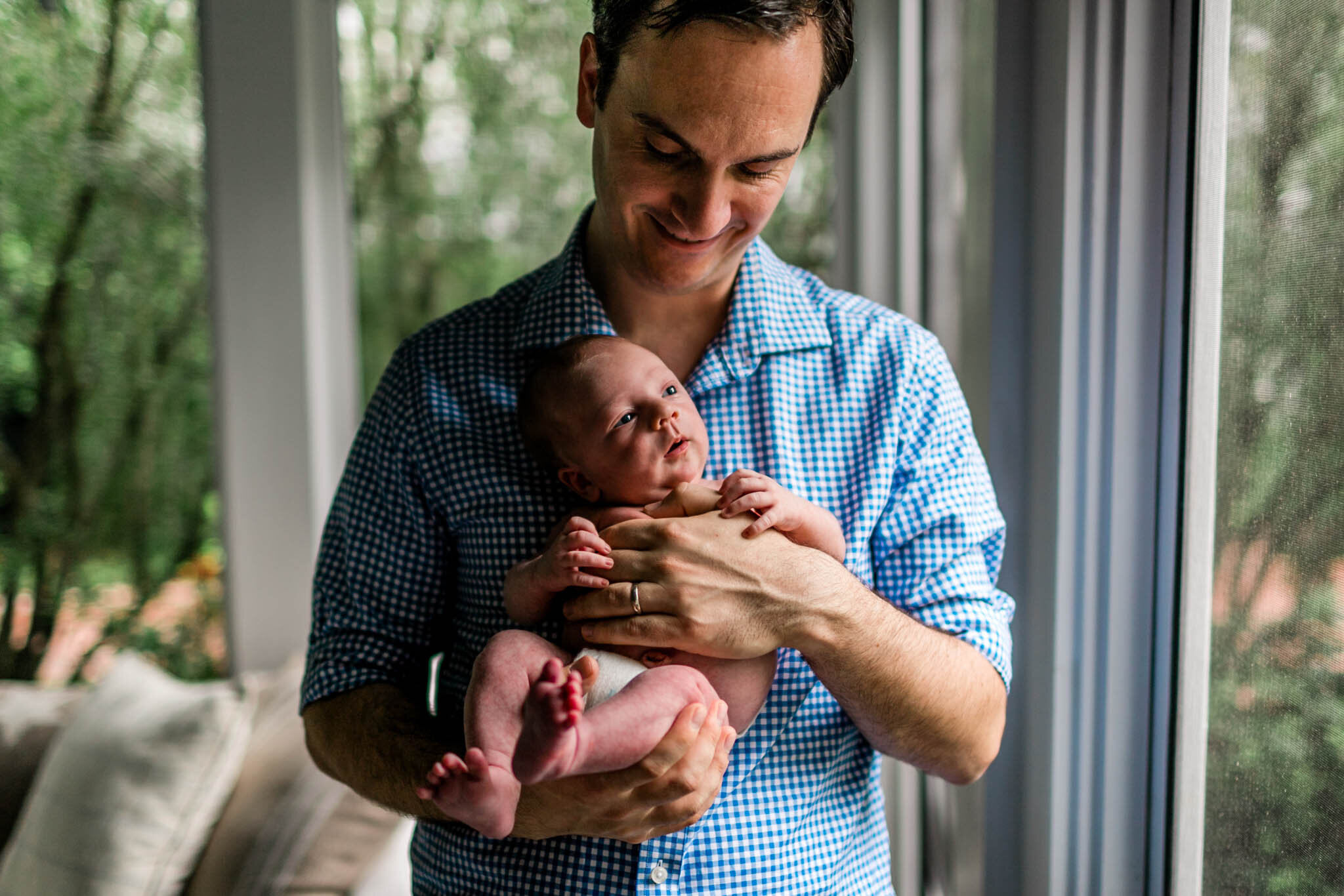 Durham Newborn Photographer | By G. Lin Photography | Father holding baby boy in his arms by window light