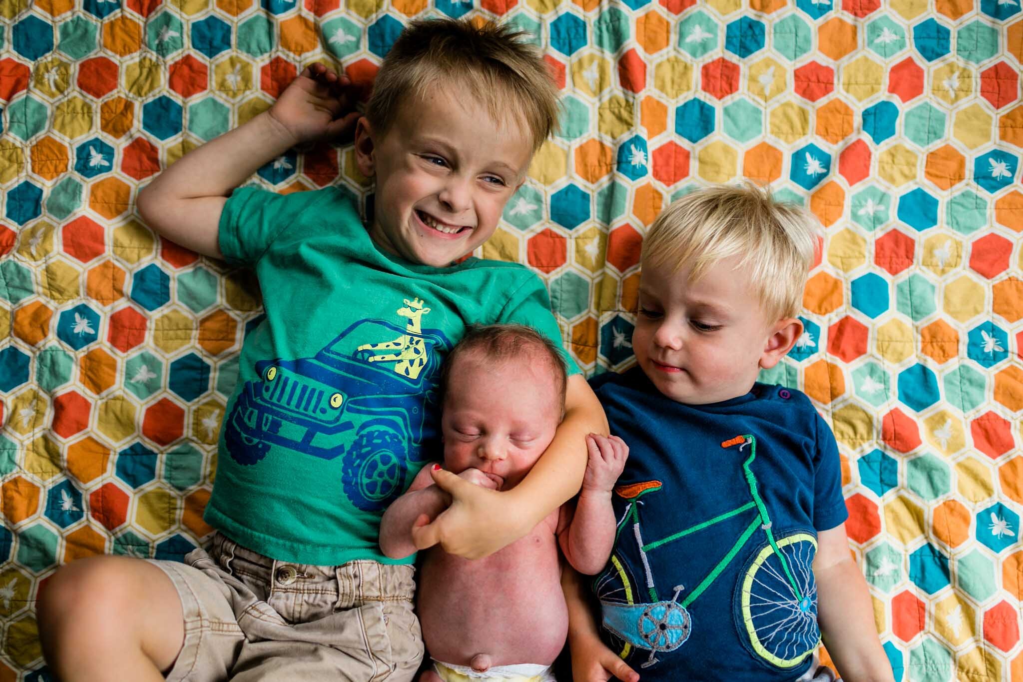 Durham Newborn Photographer | By G. Lin Photography | Organic portrait of three boys laying on quilt and smiling