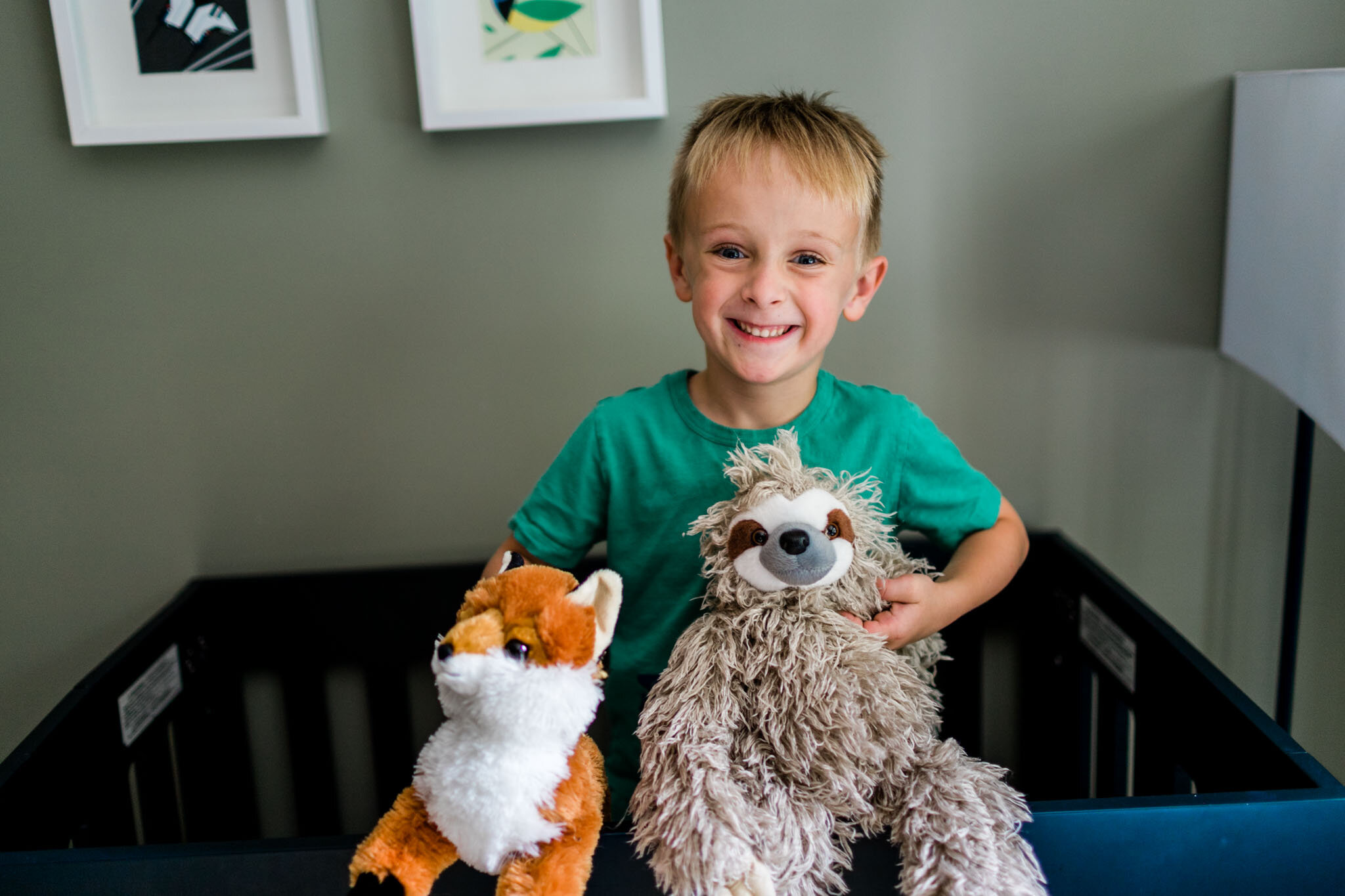 Durham Newborn Photographer | By G. Lin Photography | boy holding stuffed animals and smiling at camera