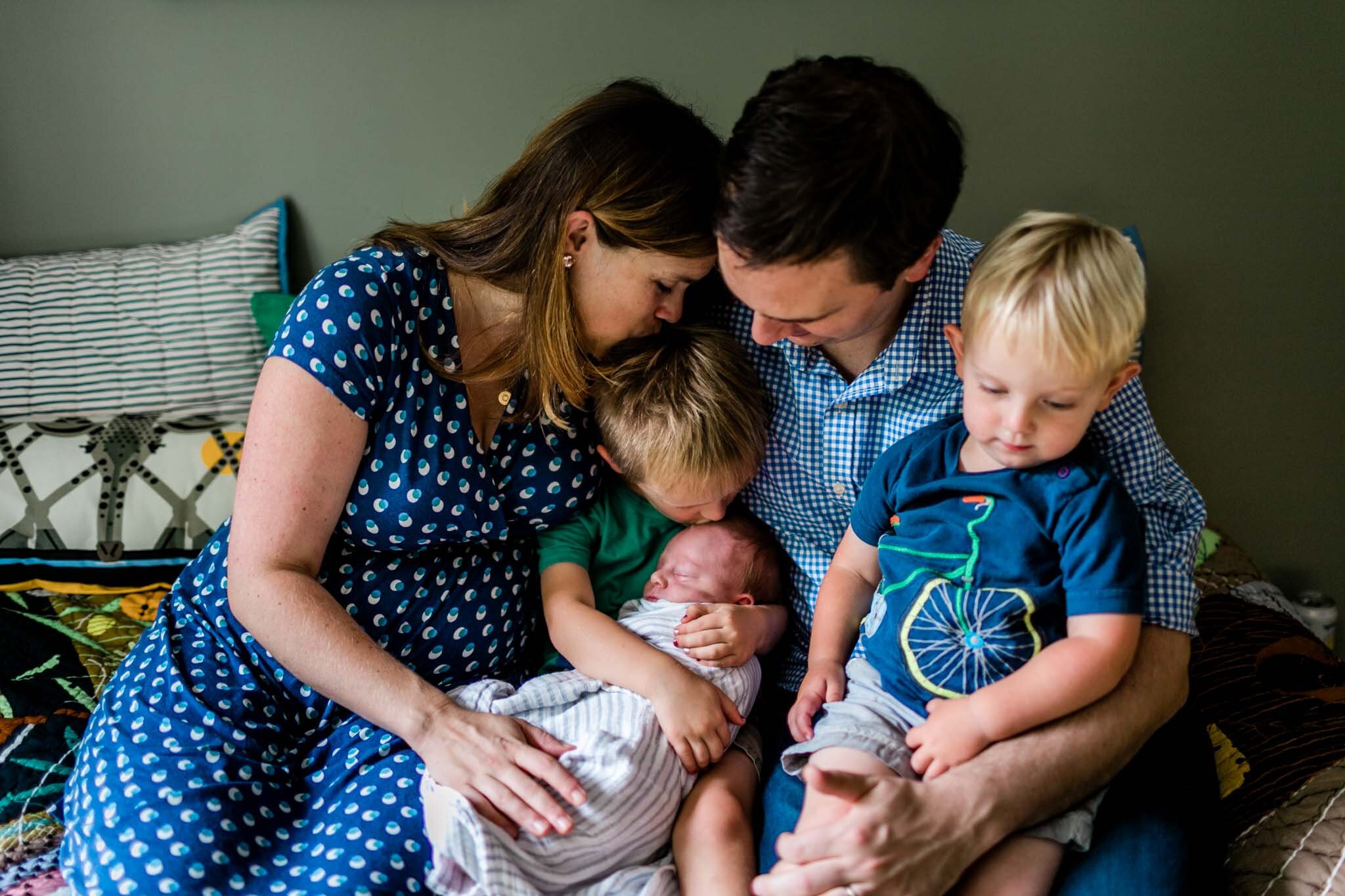 Durham Newborn Photographer | By G. Lin Photography | family sitting on bed and hugging each other