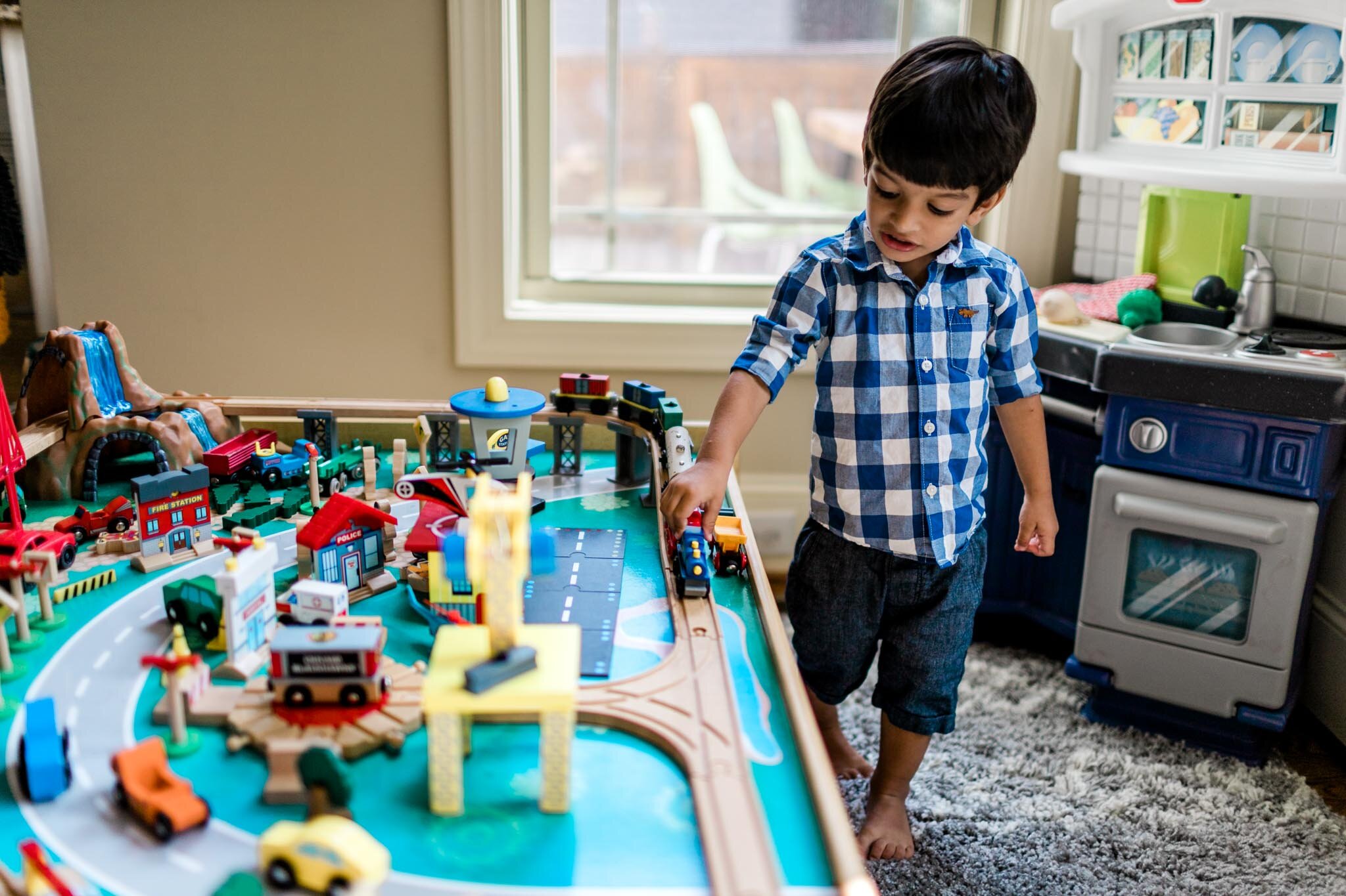 Durham Photographer | By G. Lin Photography | Boy playing with trains inside home
