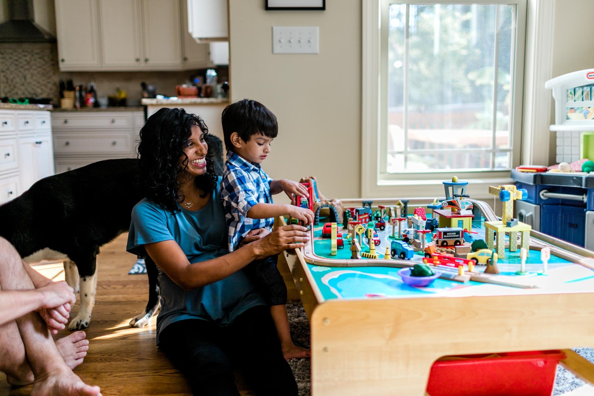 Durham Maternity Photographer | By G. Lin Photography | Mother playing trains with son inside home