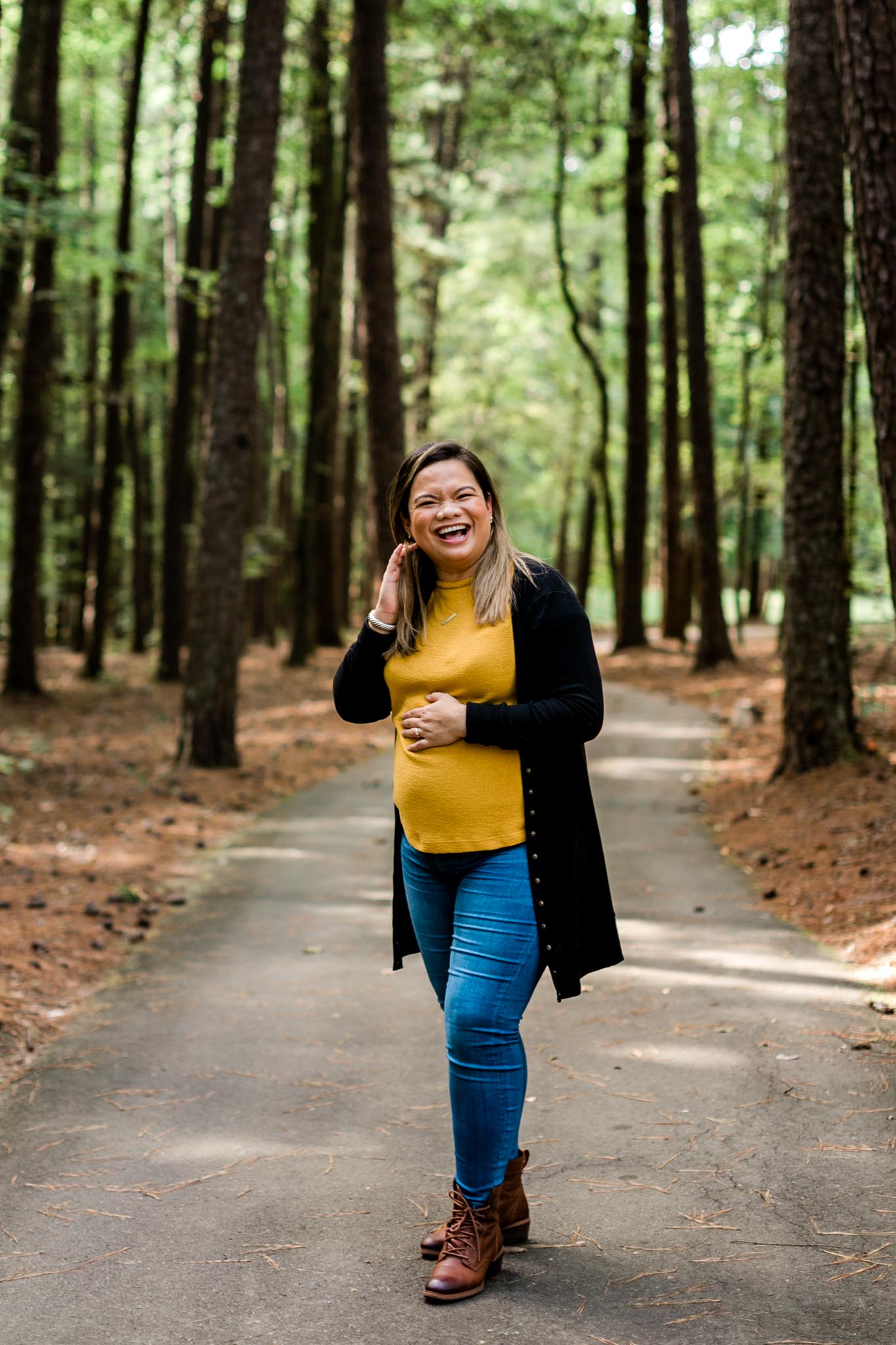 Maternity Photo at Umstead Park | Raleigh Maternity Photographer | By G. Lin Photography | Woman laughing and smiling at camera in forest