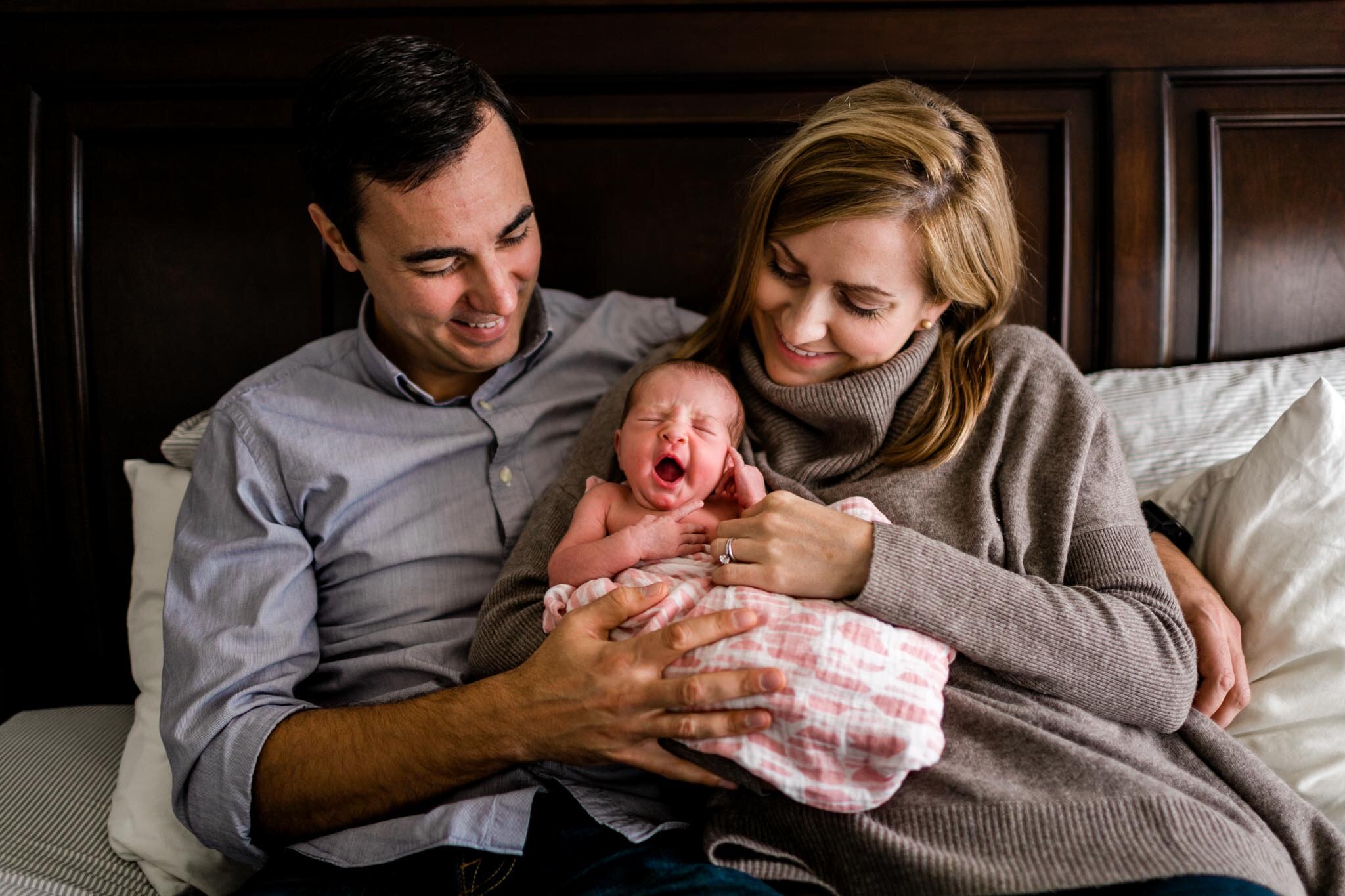 Baby girl yawning with parents by her side | Raleigh Newborn Photographer | By G. Lin Photography