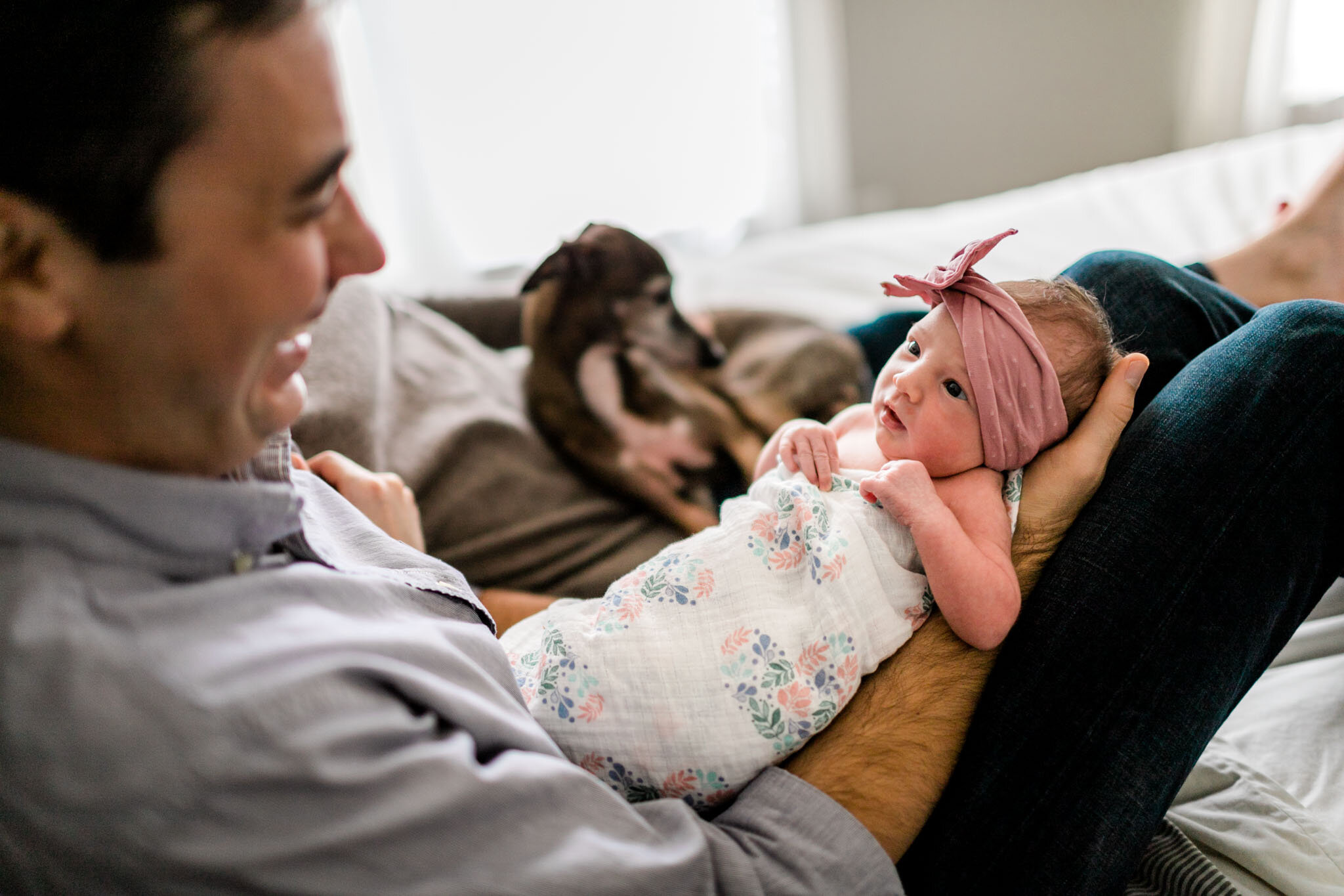 Baby girl looking at parents on bed | Durham Newborn Photographer | By G. Lin Photography 