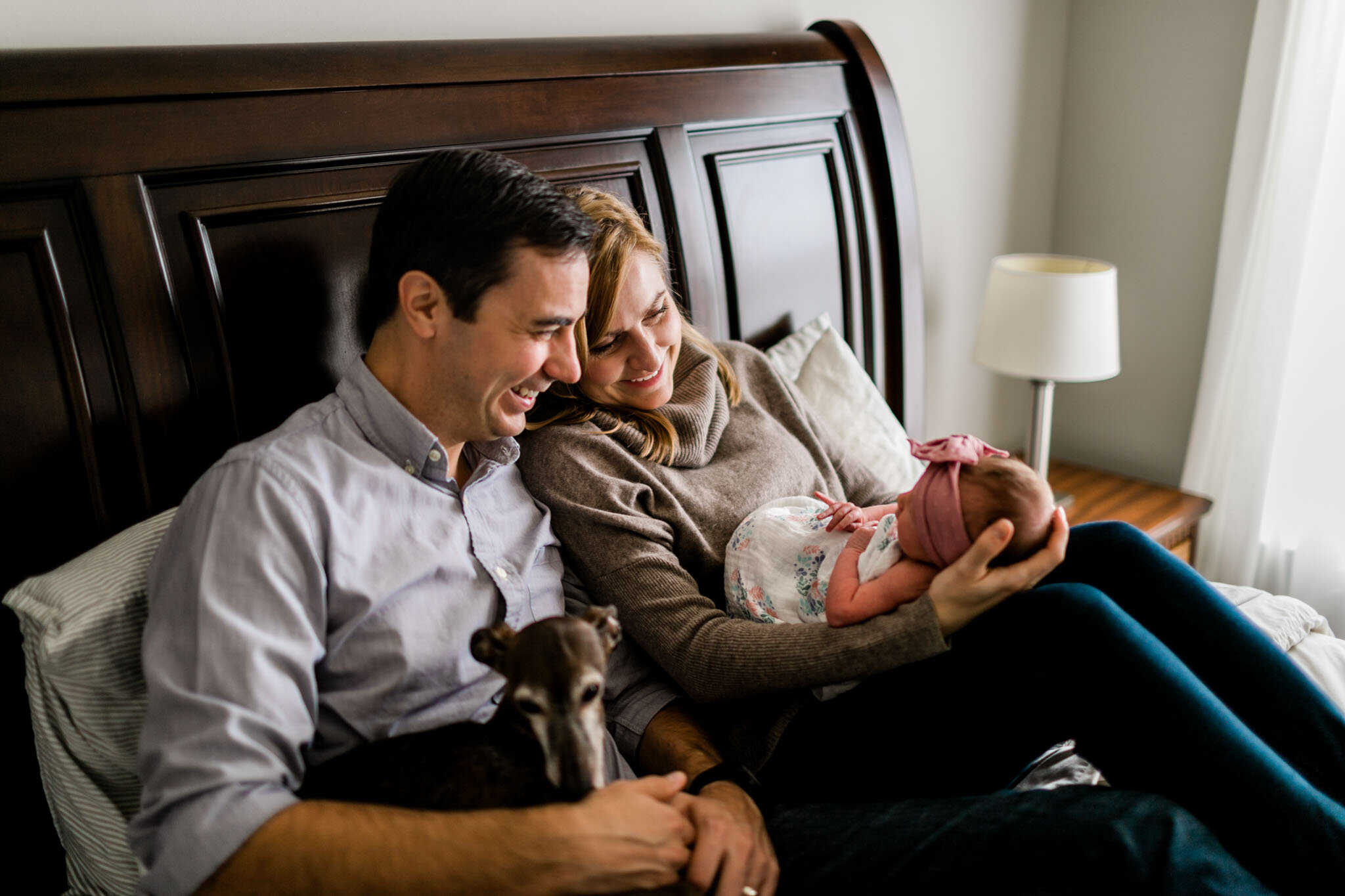 Durham Newborn Photographer | By G. Lin Photography | Parents holding baby girl on bed