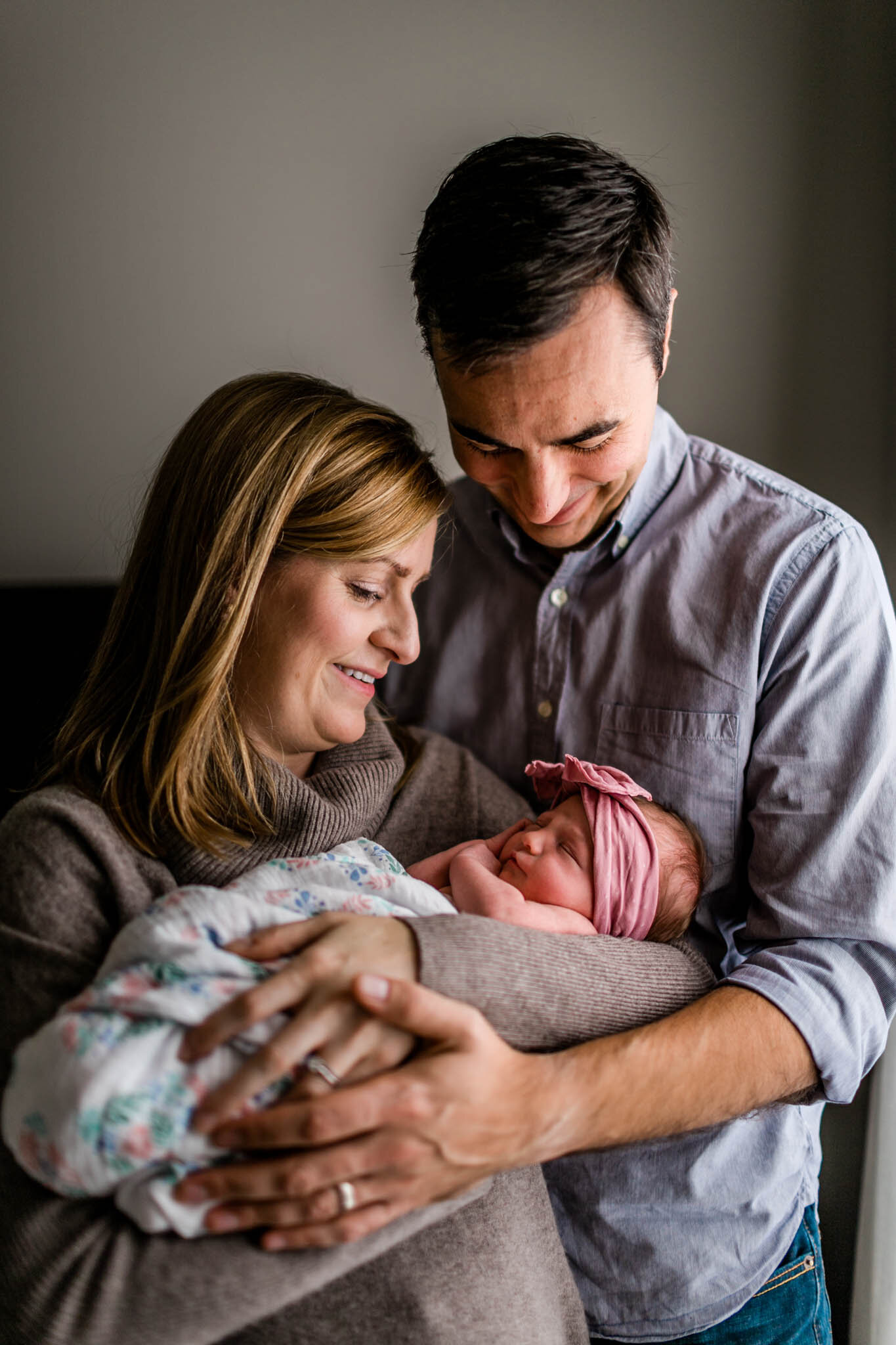 Parents holding baby girl by window at home | Raleigh Newborn Photographer | By G. Lin Photography