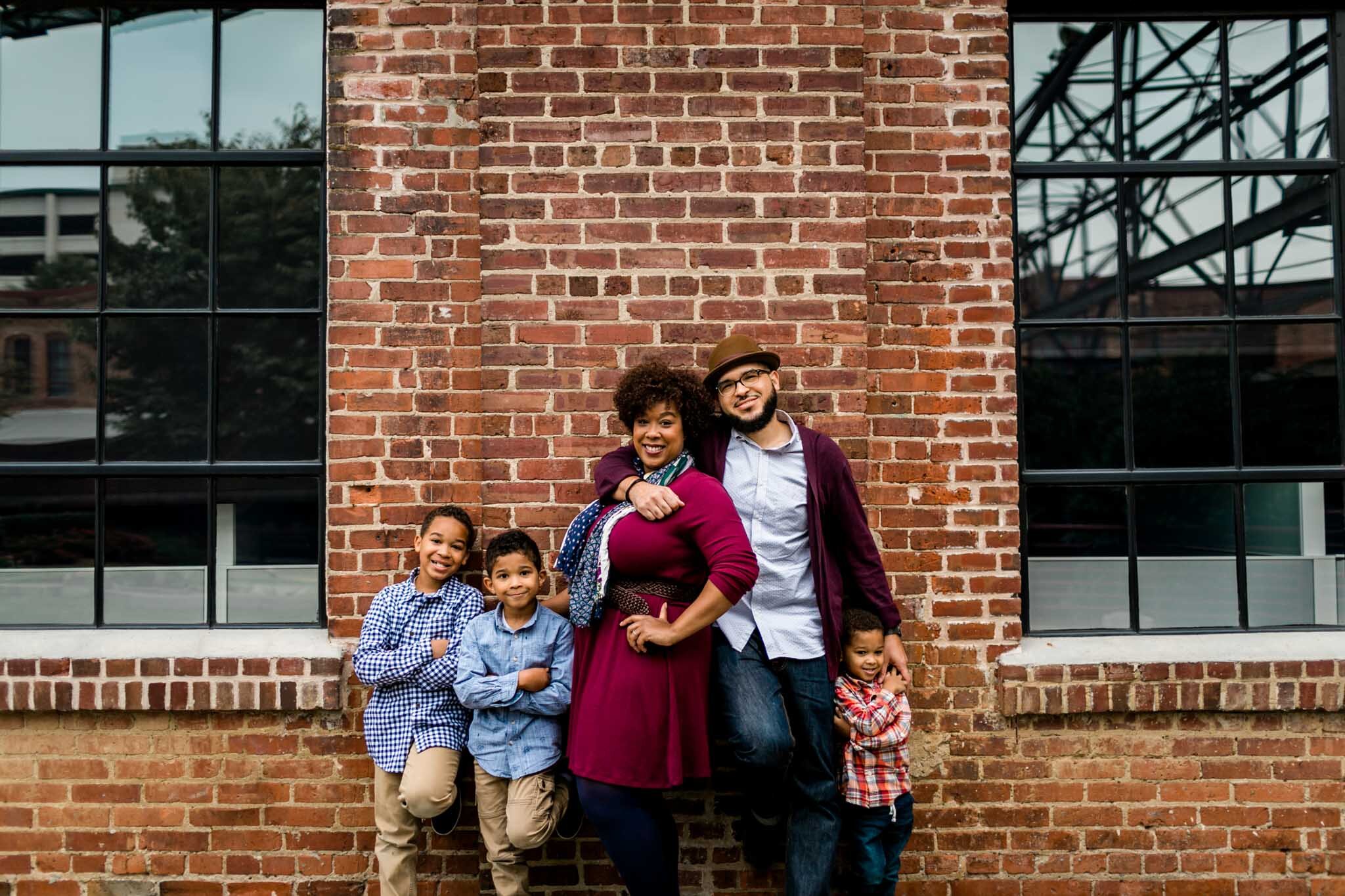 Durham Family Photographer | By G. Lin Photography | Family standing against brick wall in downtown Durham