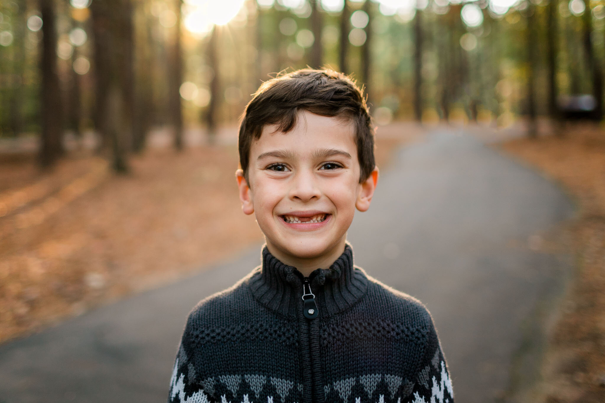 Raleigh Family Photographer | By G. Lin Photography | Boy smiling at camera at Umstead Park