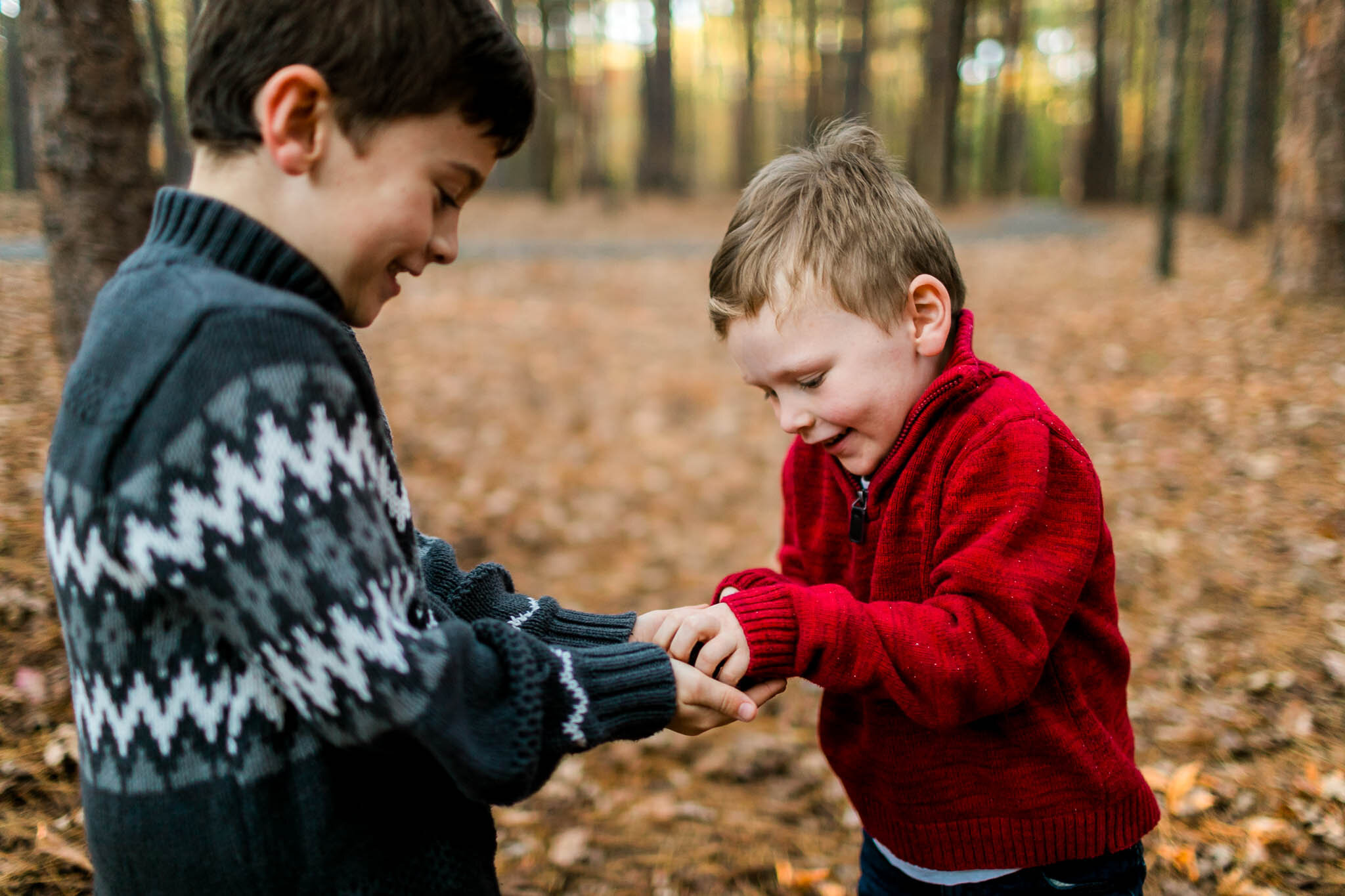 Raleigh Family Photographer | By G. Lin Photography | Boy passing toad to his brother at park