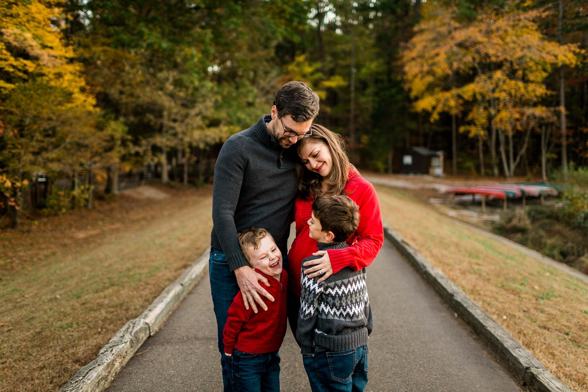 Raleigh Family Photographer | By G. Lin Photography | Candid family photo of parents hugging children at Umstead Park