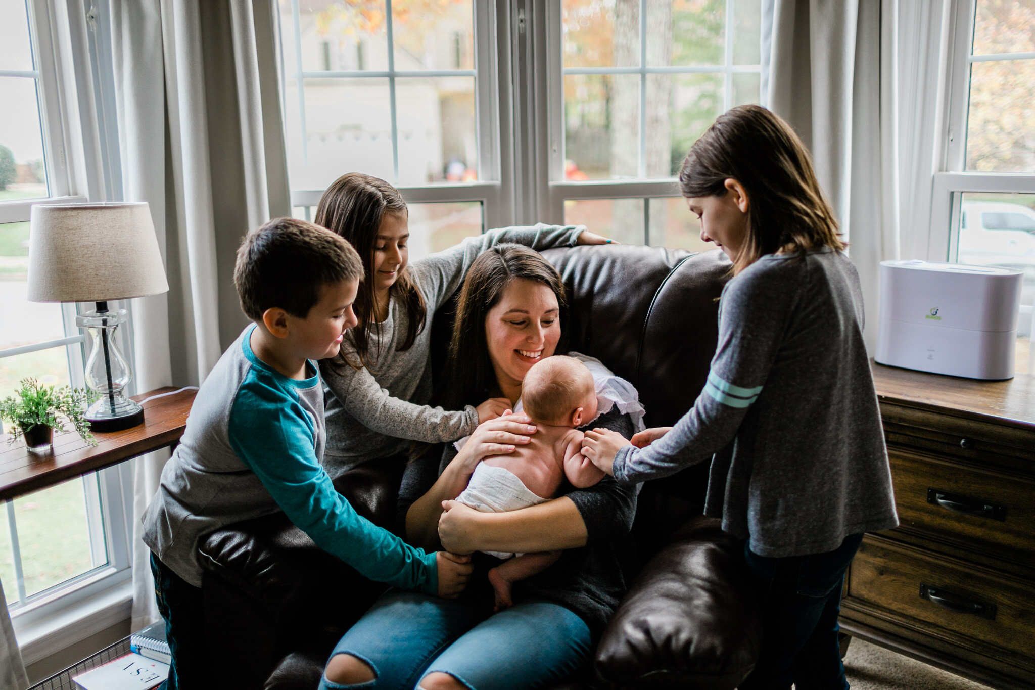 Raleigh Newborn Photographer | By G. Lin Photography | Candid photo of siblings and mother next to window