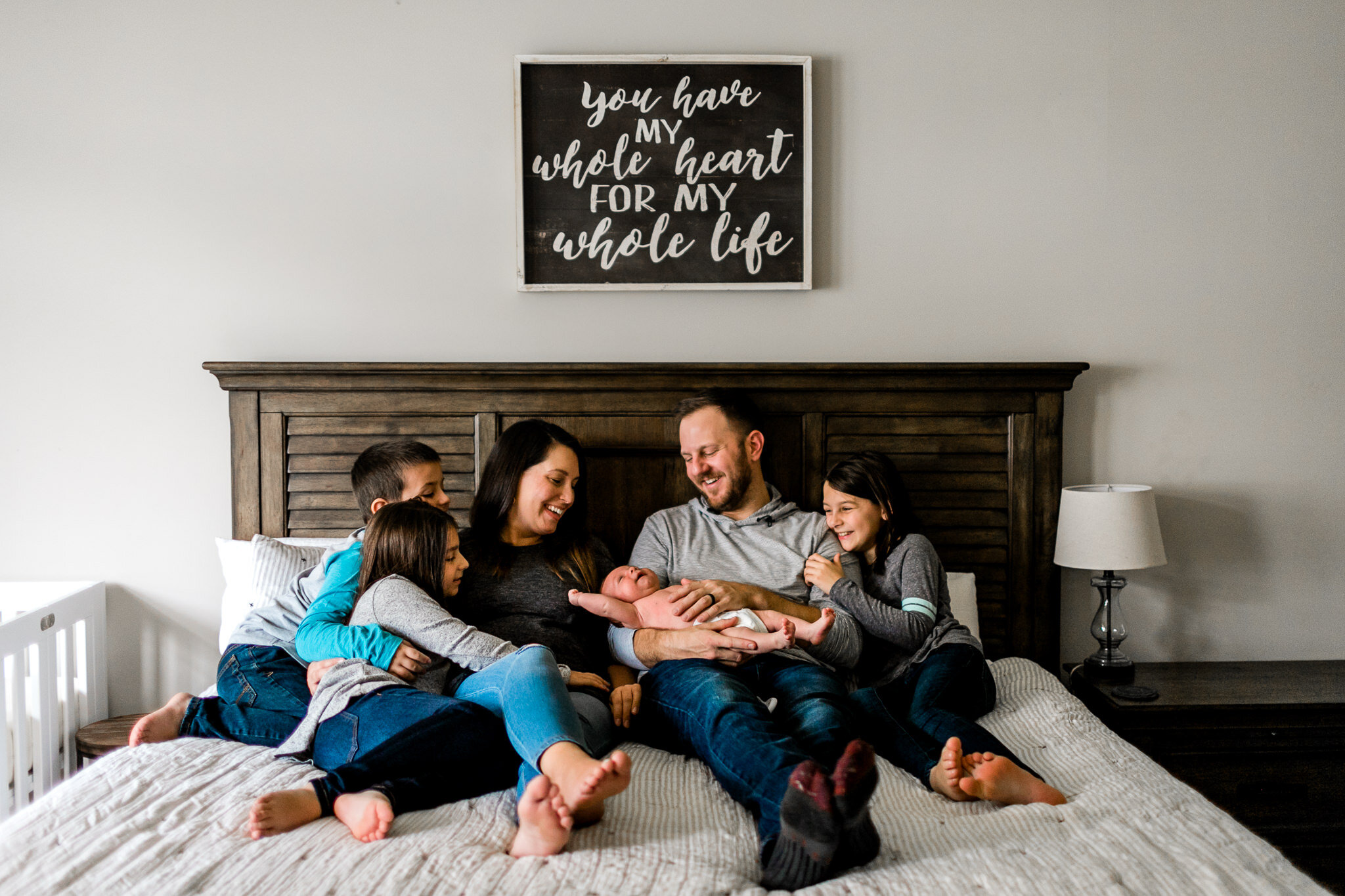 Raleigh Family Photographer | By G. Lin Photography | Lifestyle newborn session at home with family sitting together on bed