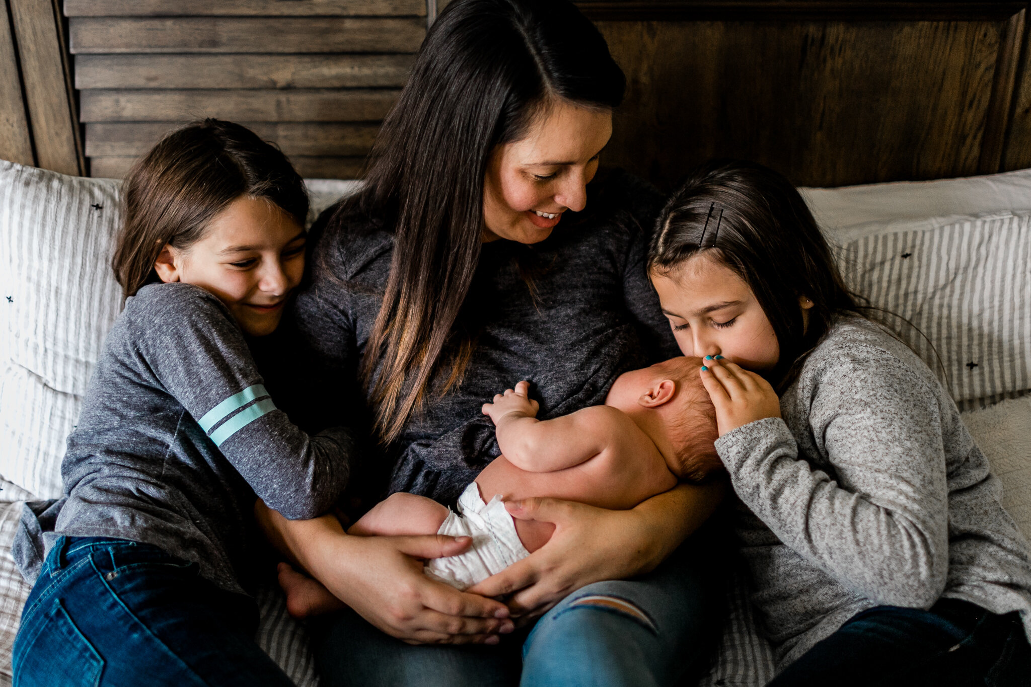 Raleigh Newborn Photographer | By G. Lin Photography | Organic photo of mother and daughters snuggling with newborn baby