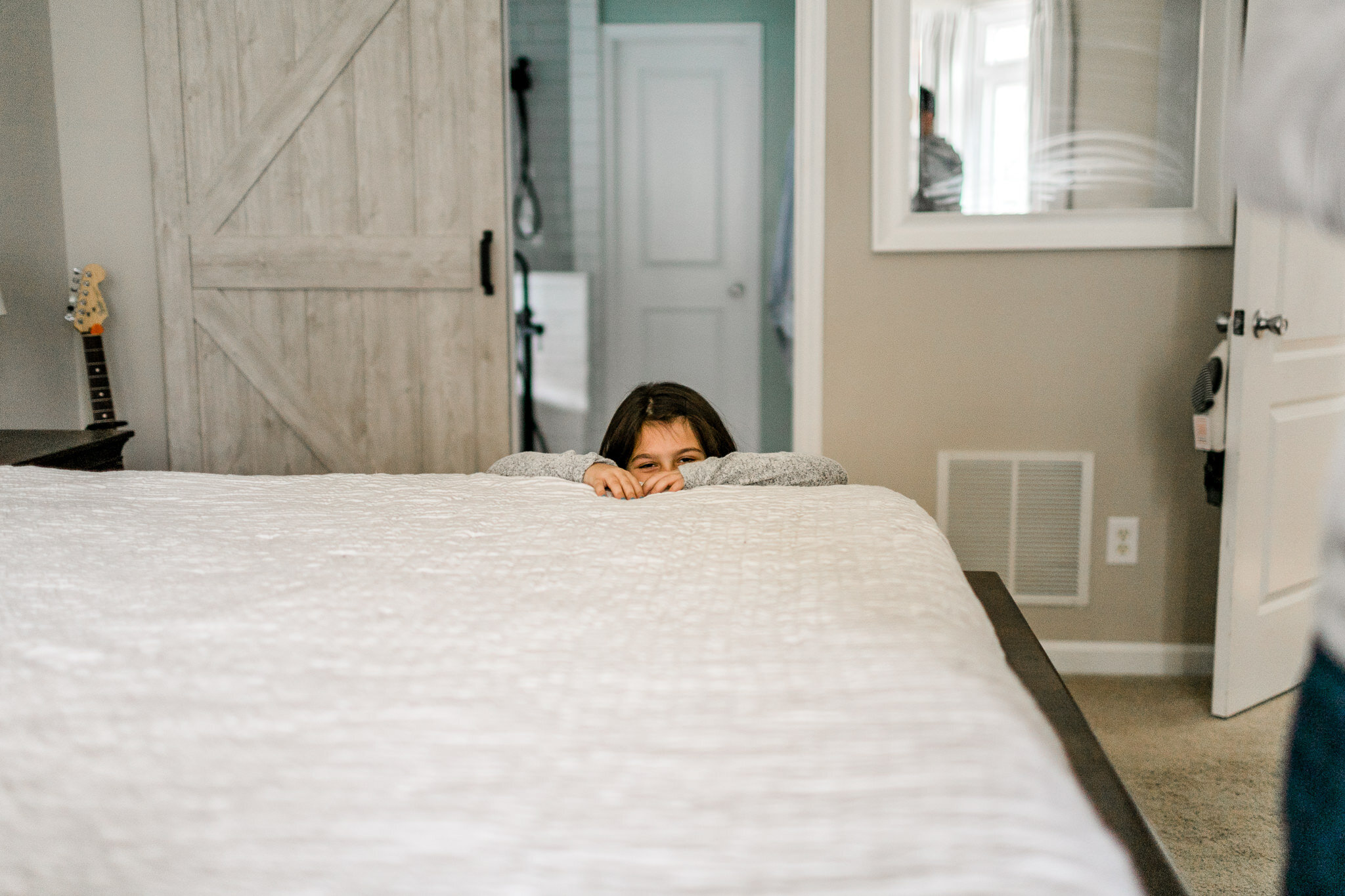 Lifestyle Newborn Session at Home | Raleigh Newborn Photographer | By G. Lin Photography | Girl peeking over bed