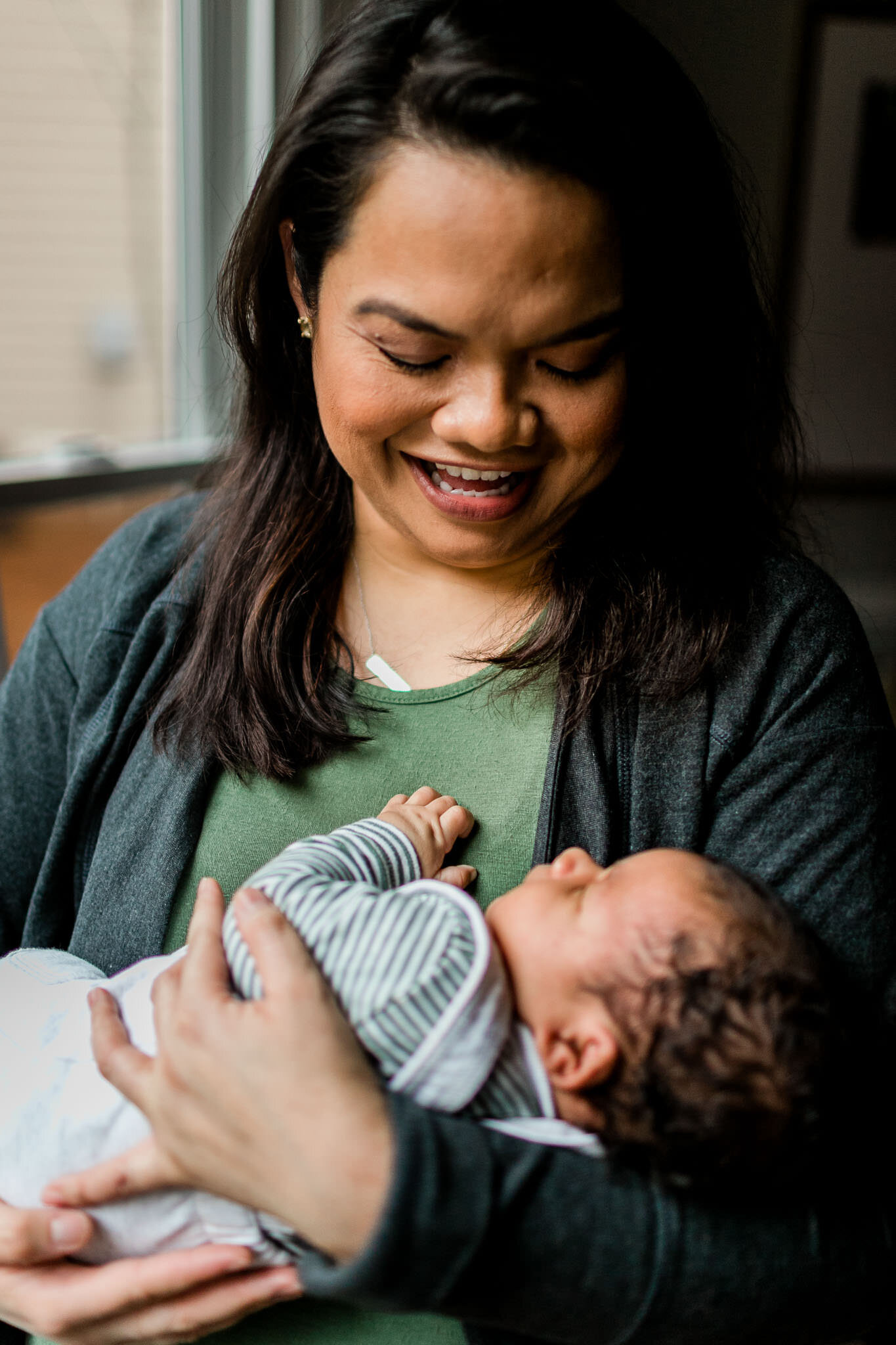 Raleigh Newborn Photographer | By G. Lin Photography | Mother holding baby boy and smiling at home