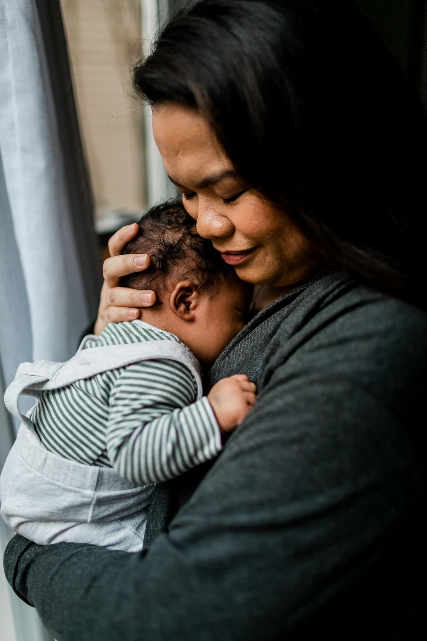 Durham Newborn Photographer | By G. Lin Photography | Mother holding baby by the window