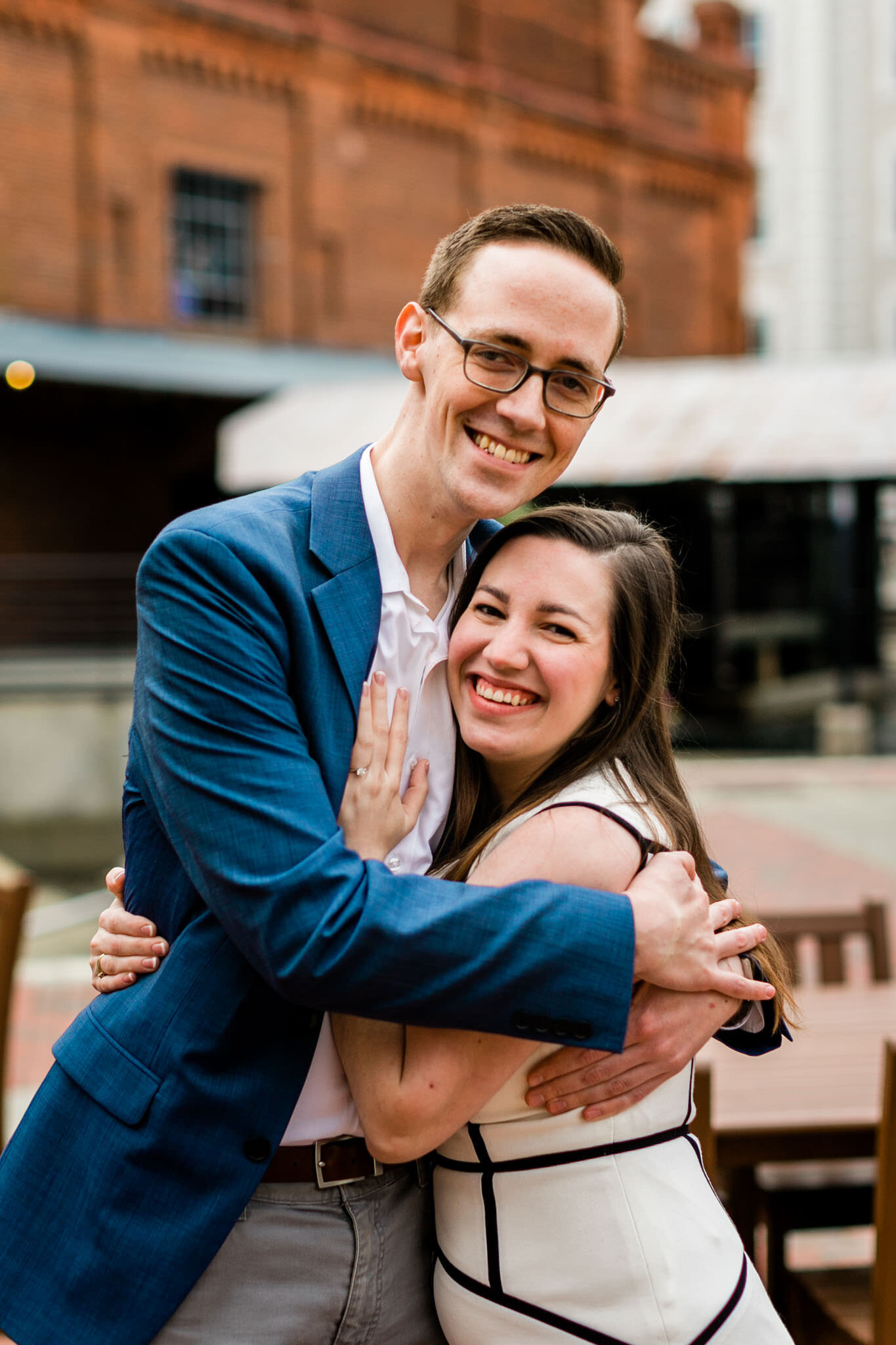 Durham Engagement Photographer | By G. Lin Photography | Couple hugging one another after surprise proposal at American Tobacco Campus