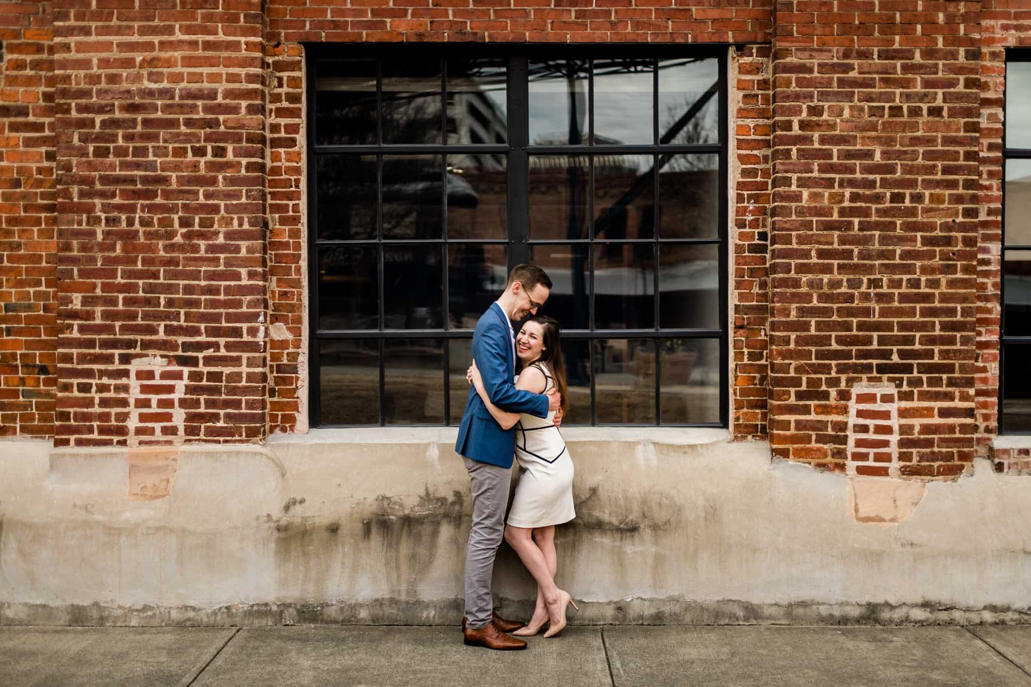 Durham Photographer | By G. Lin Photography | Couple portrait in front of brick wall at American Tobacco Campus