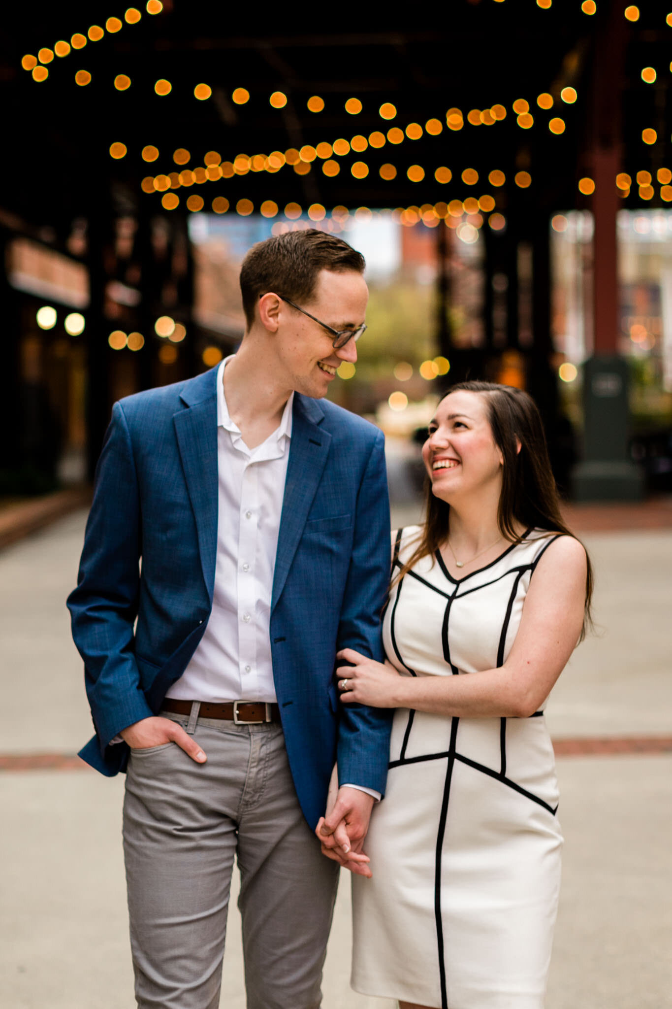 Couple smiling and laughing while walking at American Tobacco Campus | Durham Engagement Photographer | By G. Lin Photography