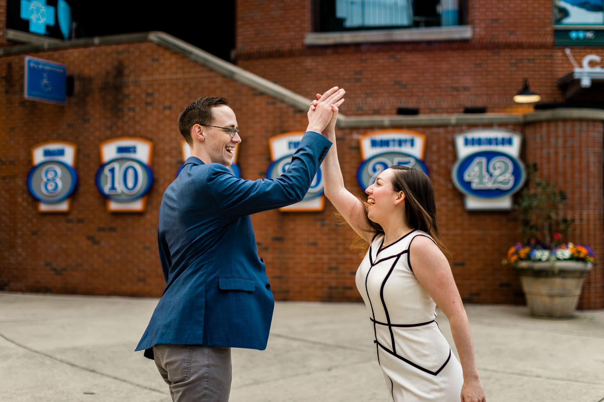 Durham Engagement Photographer | By G. Lin Photography | Couple giving each other high fives by Bull Stadium