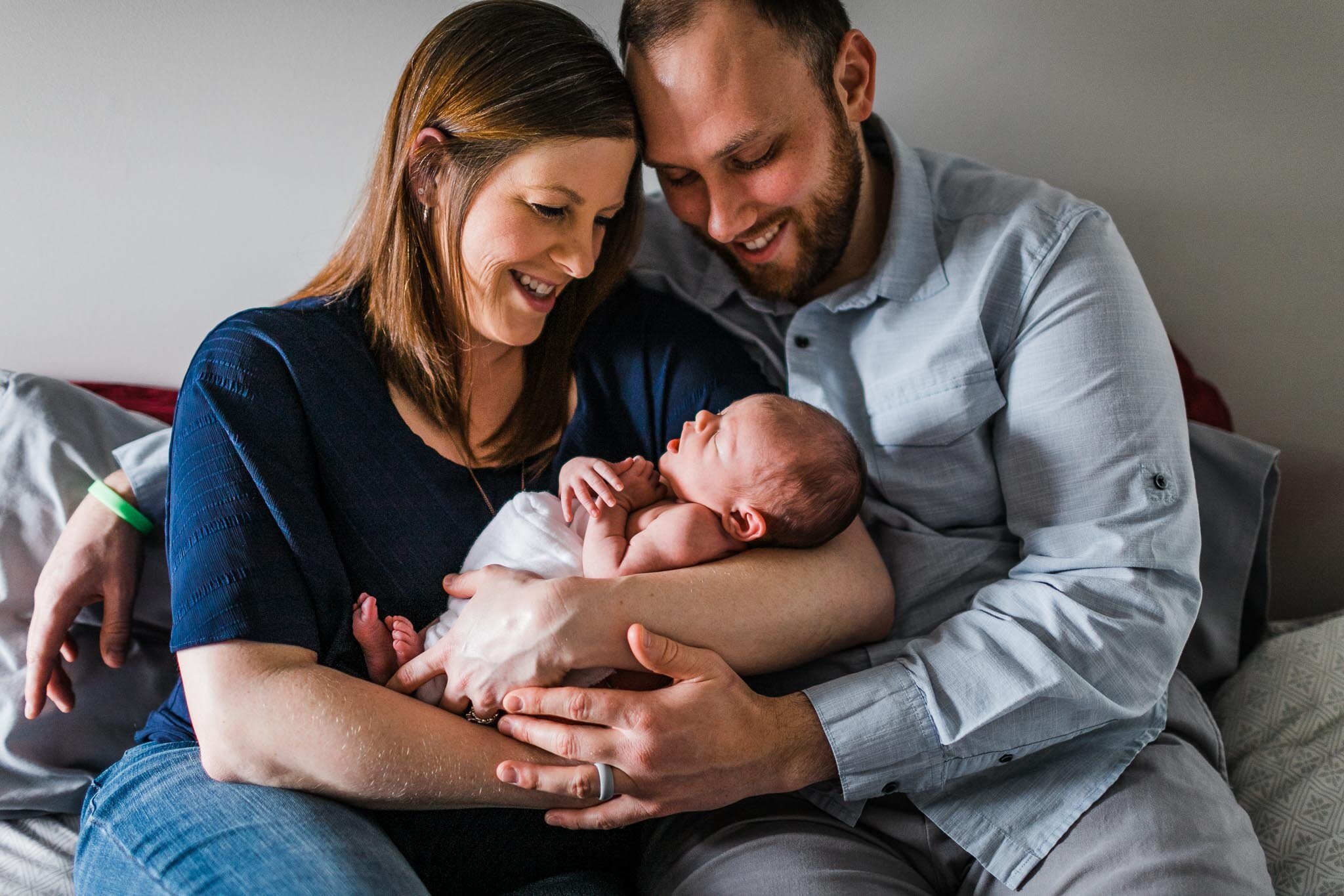Raleigh Newborn Photographer | By G. Lin Photography | Parents holding newborn baby on bed