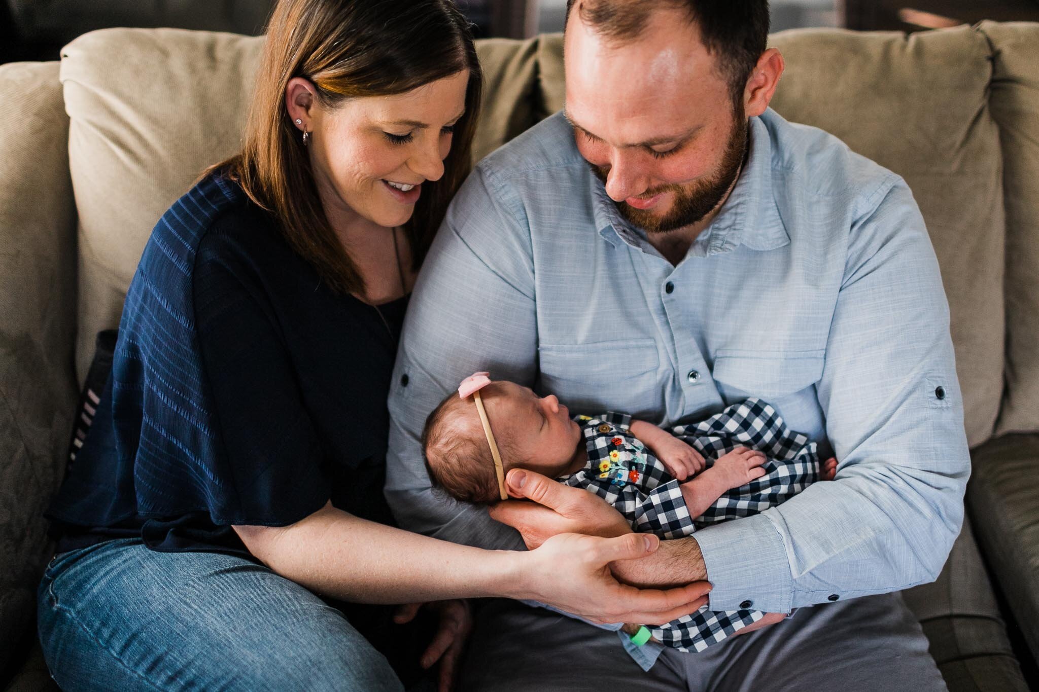 Raleigh Newborn Photographer | By G. Lin Photography | Parents holding baby on the couch