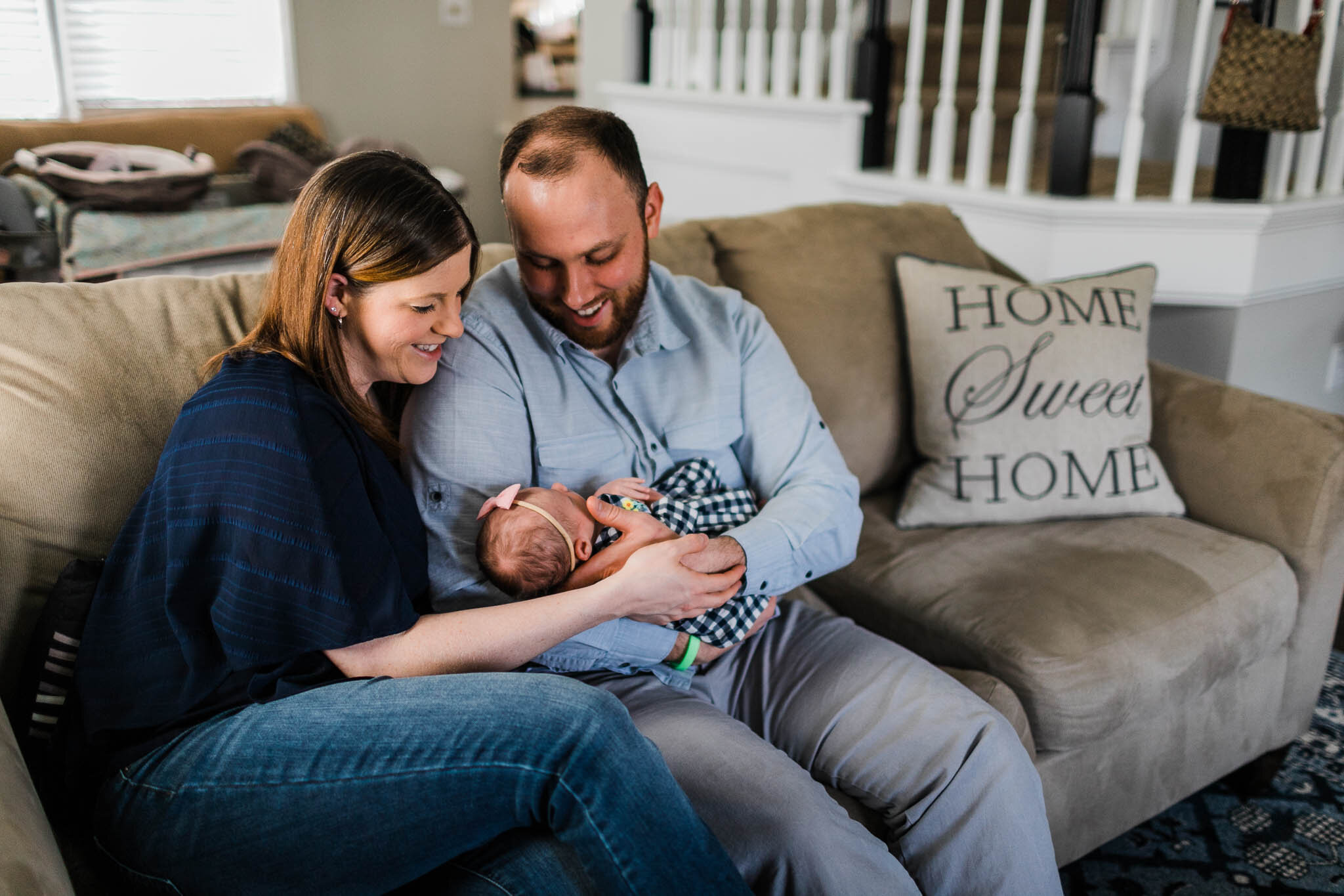 Raleigh Newborn Photographer | By G. Lin Photography | Parents smiling at baby on the couch