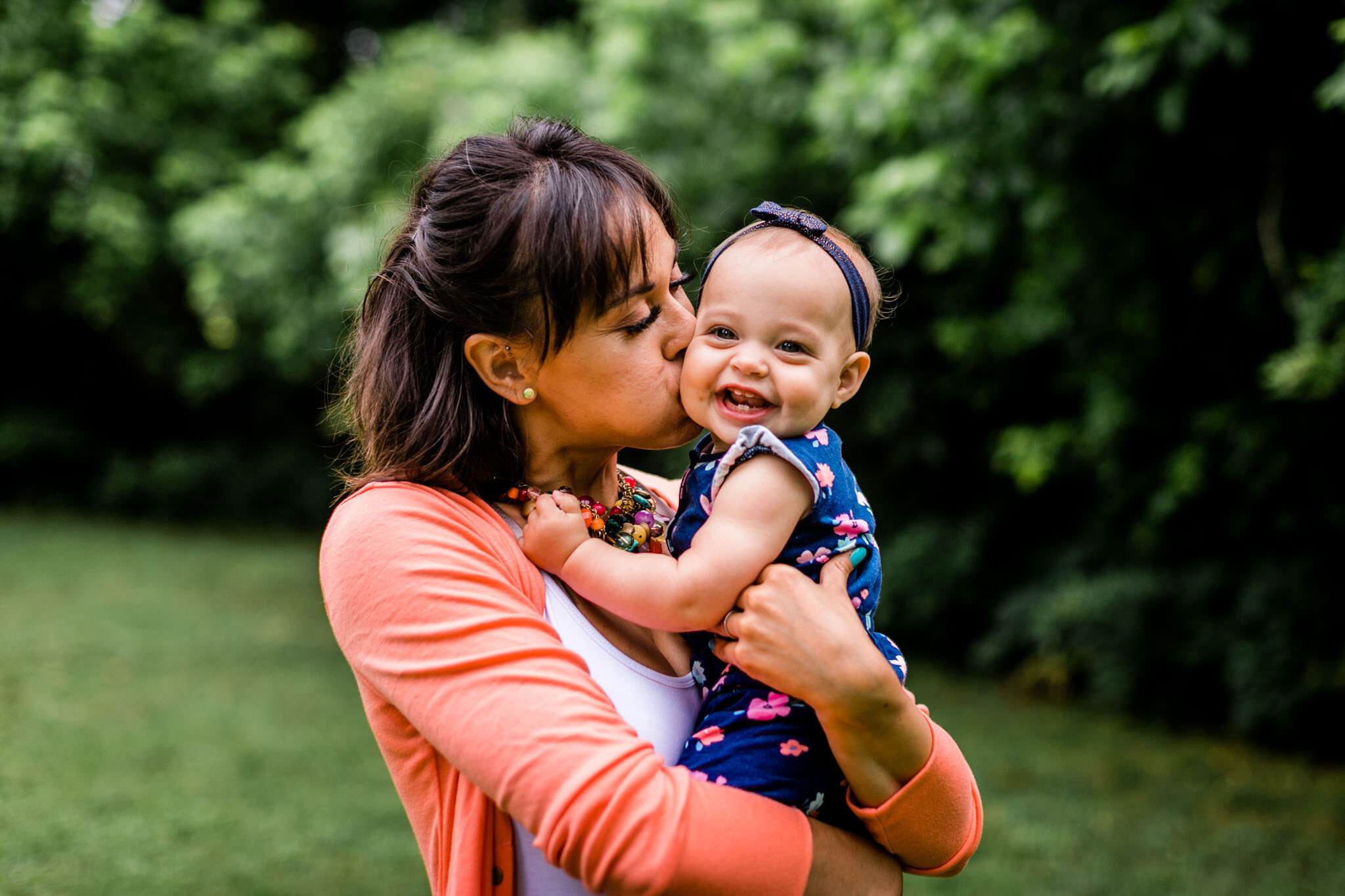 Raleigh Family Photographer | By G. Lin Photography | Mother holding baby girl and kissing her on cheek
