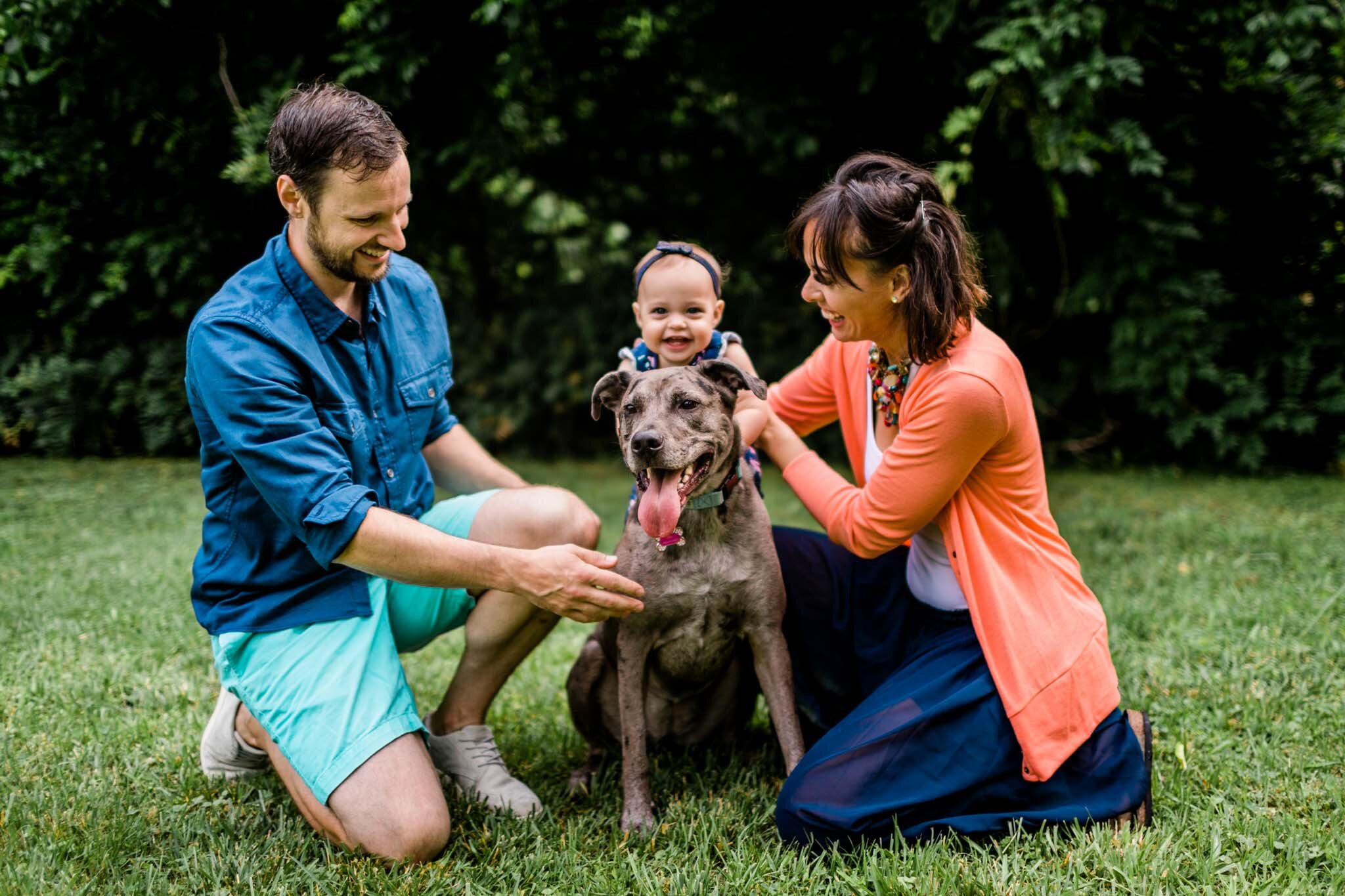Raleigh Family Photographer | By G. Lin Photography | Candid portrait of family outside with baby girl sitting on dog