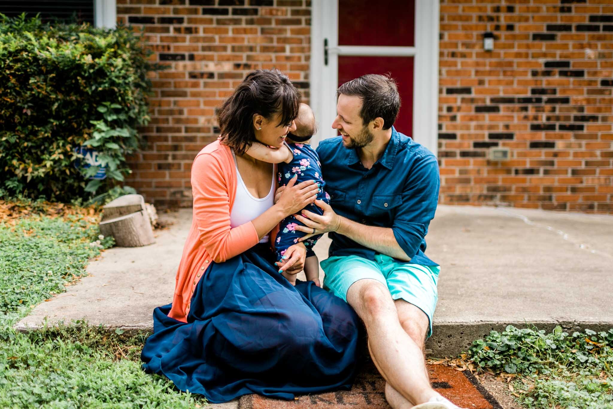 Raleigh Family Photographer | By G. Lin Photography | Parents sitting with baby girl outside on front porch