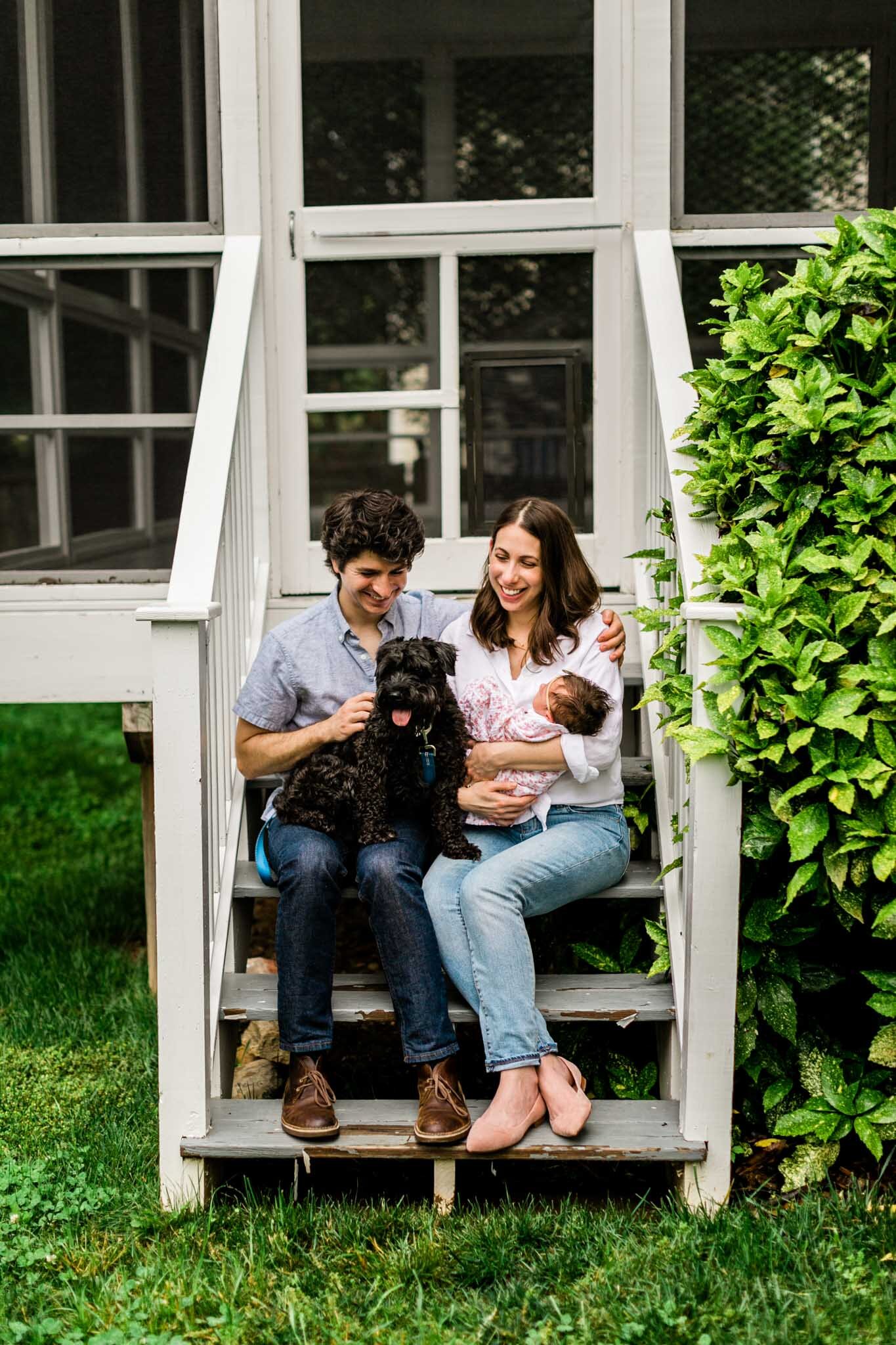 Durham Newborn Photographer | By G. Lin Photography | Candid photo of parents sitting on back porch steps with baby