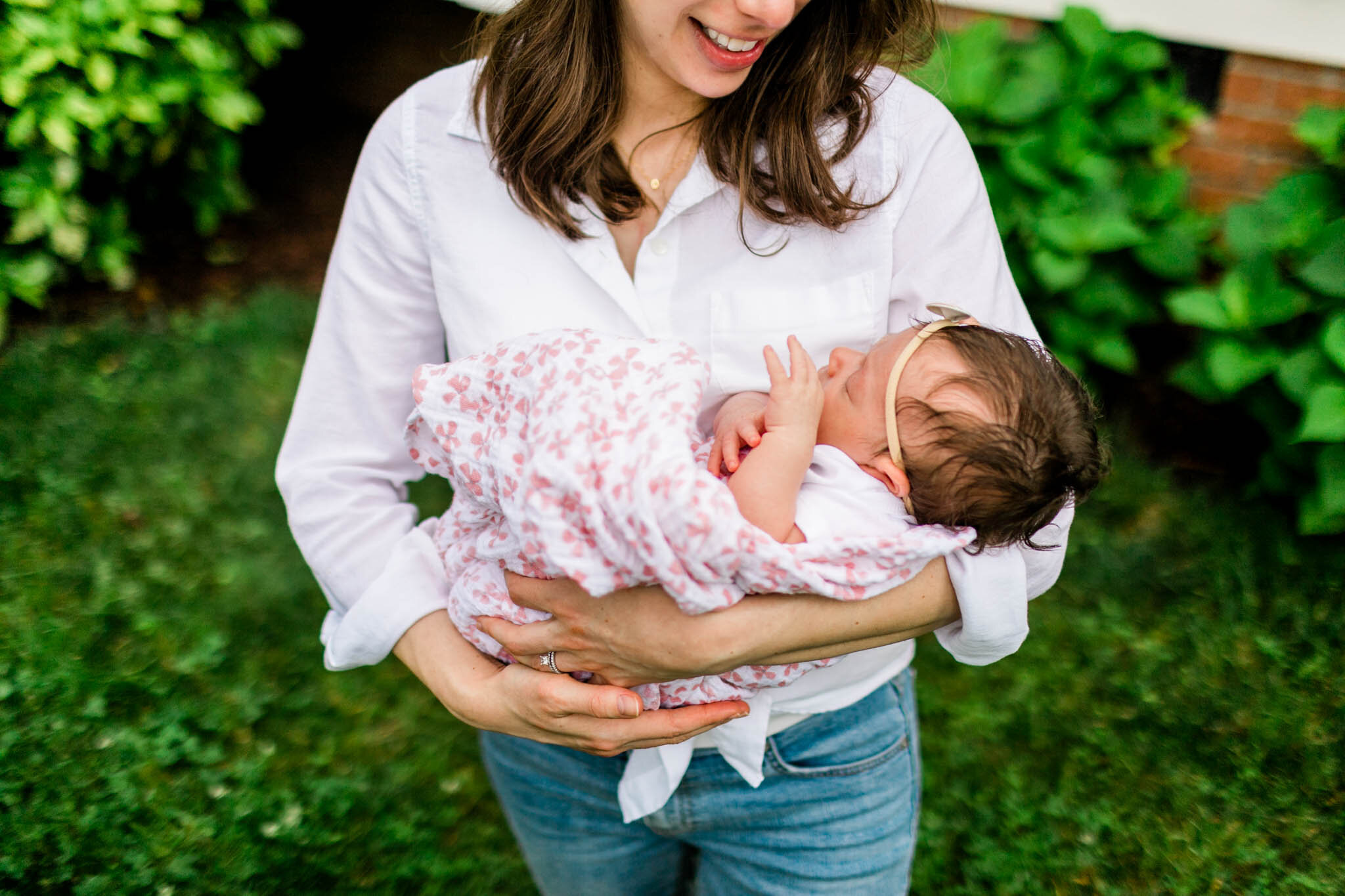 Durham Newborn Photographer | By G. Lin Photography | Mother holding baby in arms outside on grass