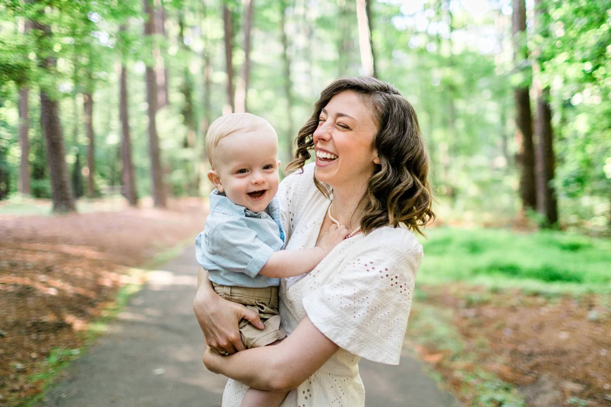 Raleigh Family Photographer | By G. Lin Photography | Umstead Park | Candid photo of mother laughing with baby boy in her arms