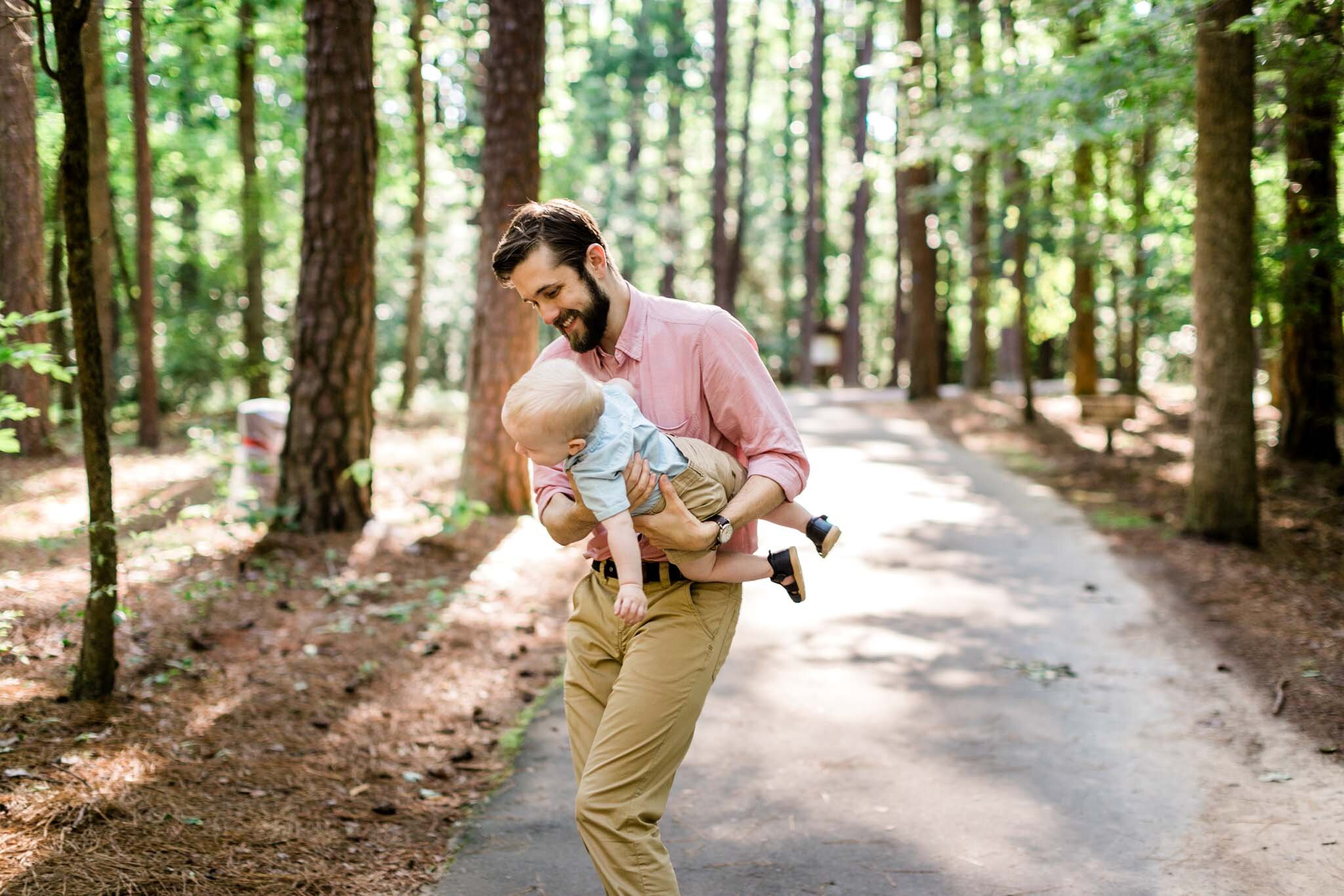 Raleigh Family Photographer | By G. Lin Photography | Umstead Park | Father holding son and spinning him around