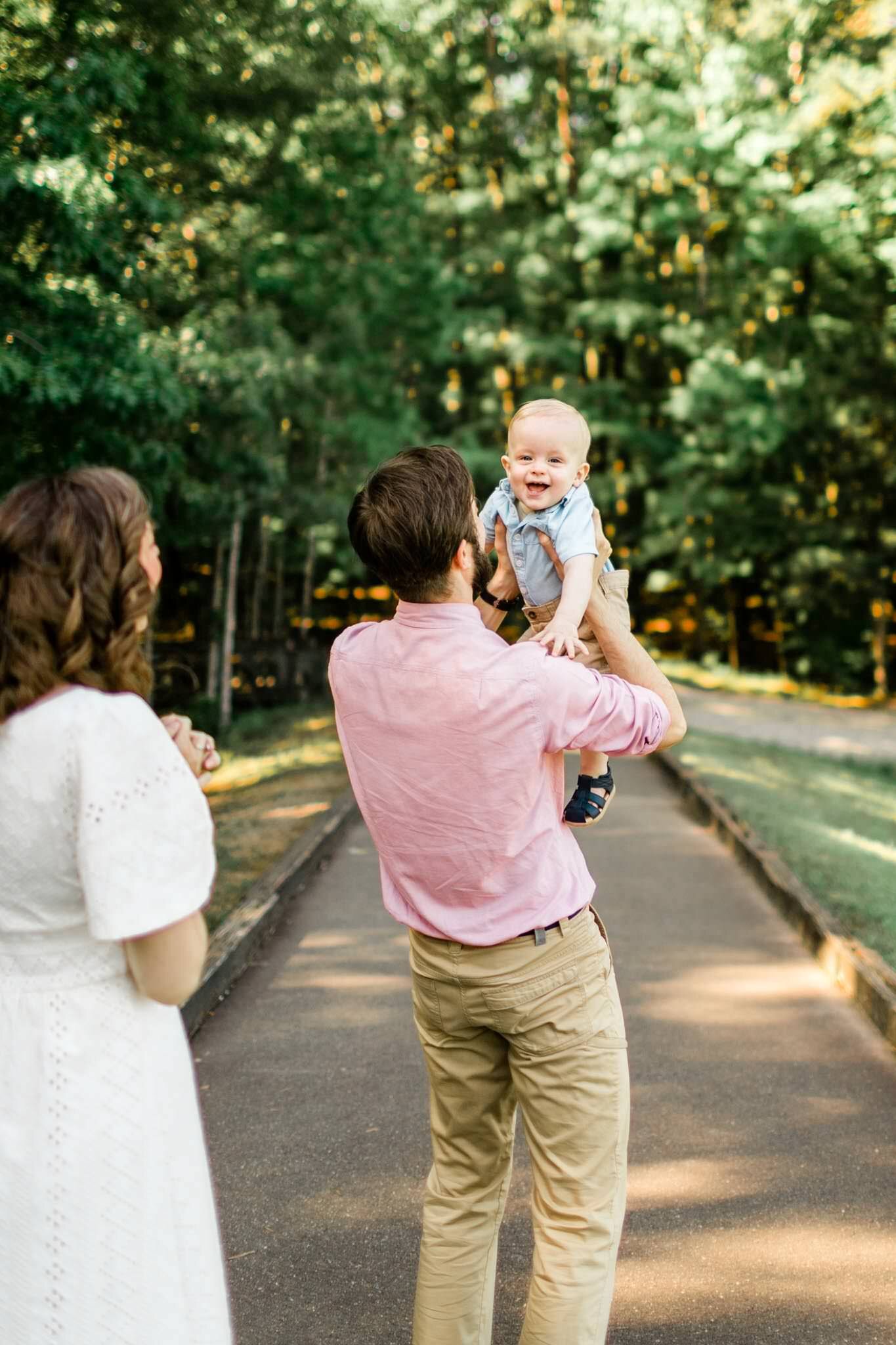 Raleigh Family Photographer | By G. Lin Photography | Umstead Park | Organic candid family photo of dad holding son outside