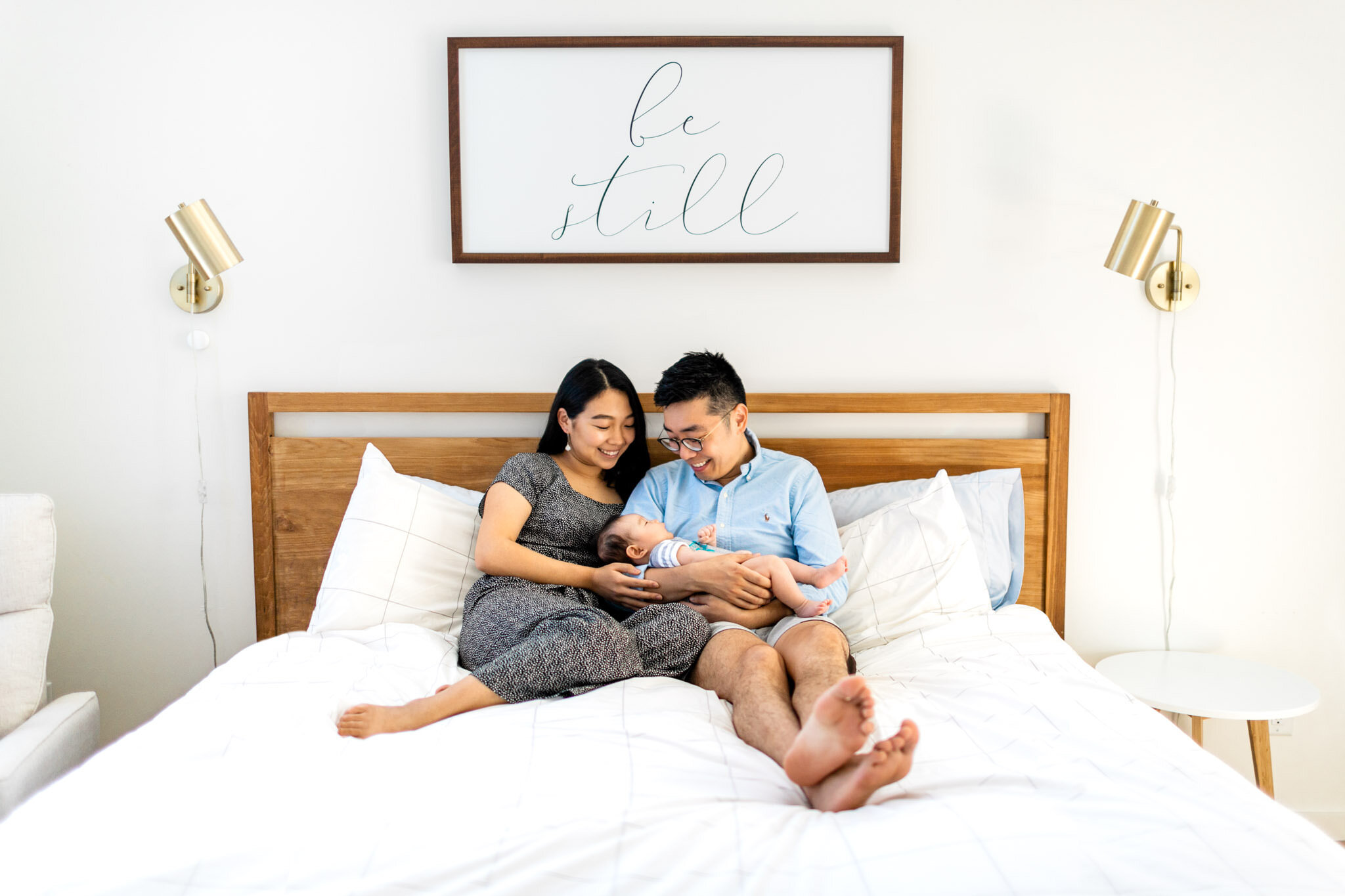 Raleigh Newborn Photographer | By G. Lin Photography | Parents holding newborn baby girl in bed