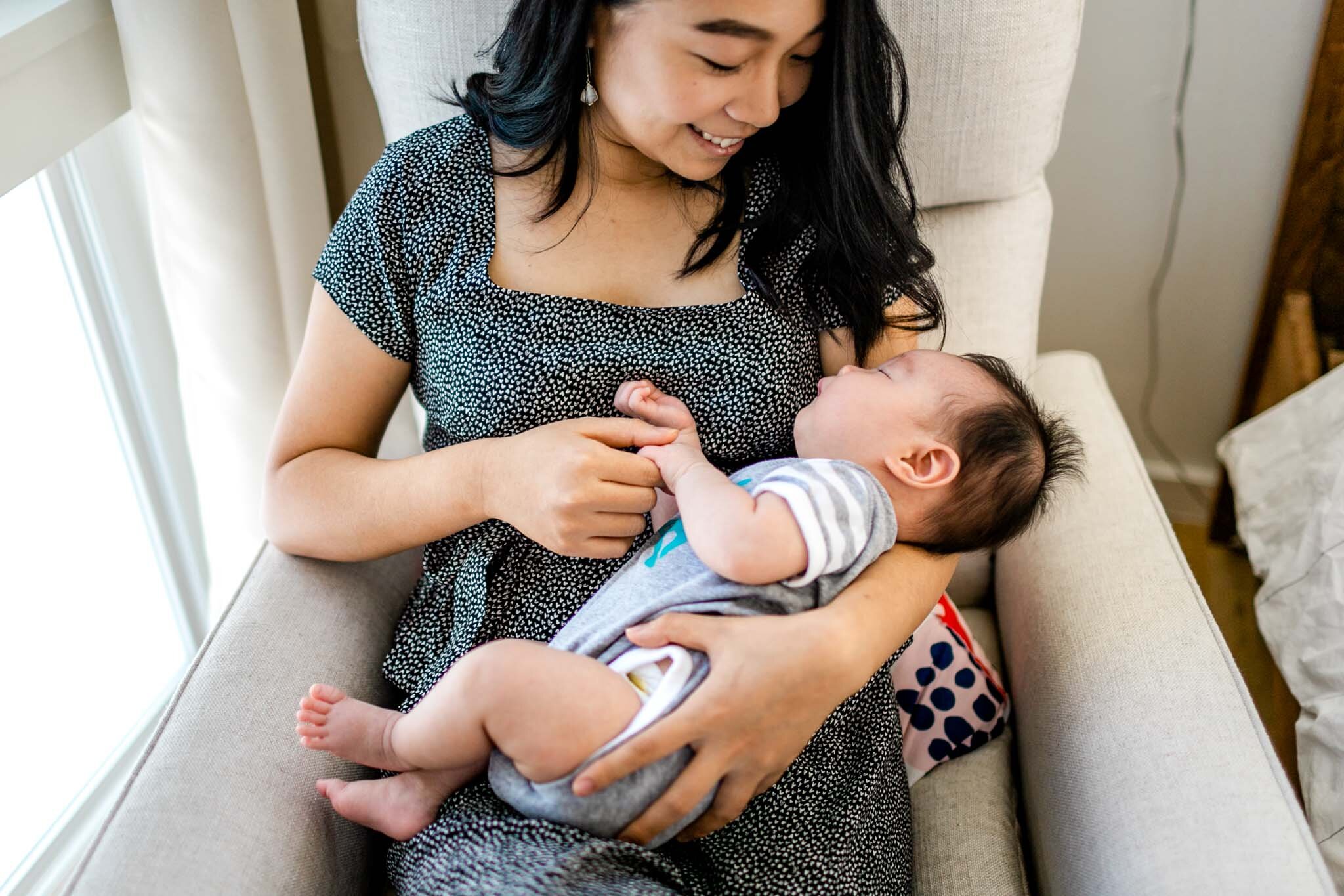 Raleigh Newborn Photographer | By G. Lin Photography | Mother holding baby girl in armchair