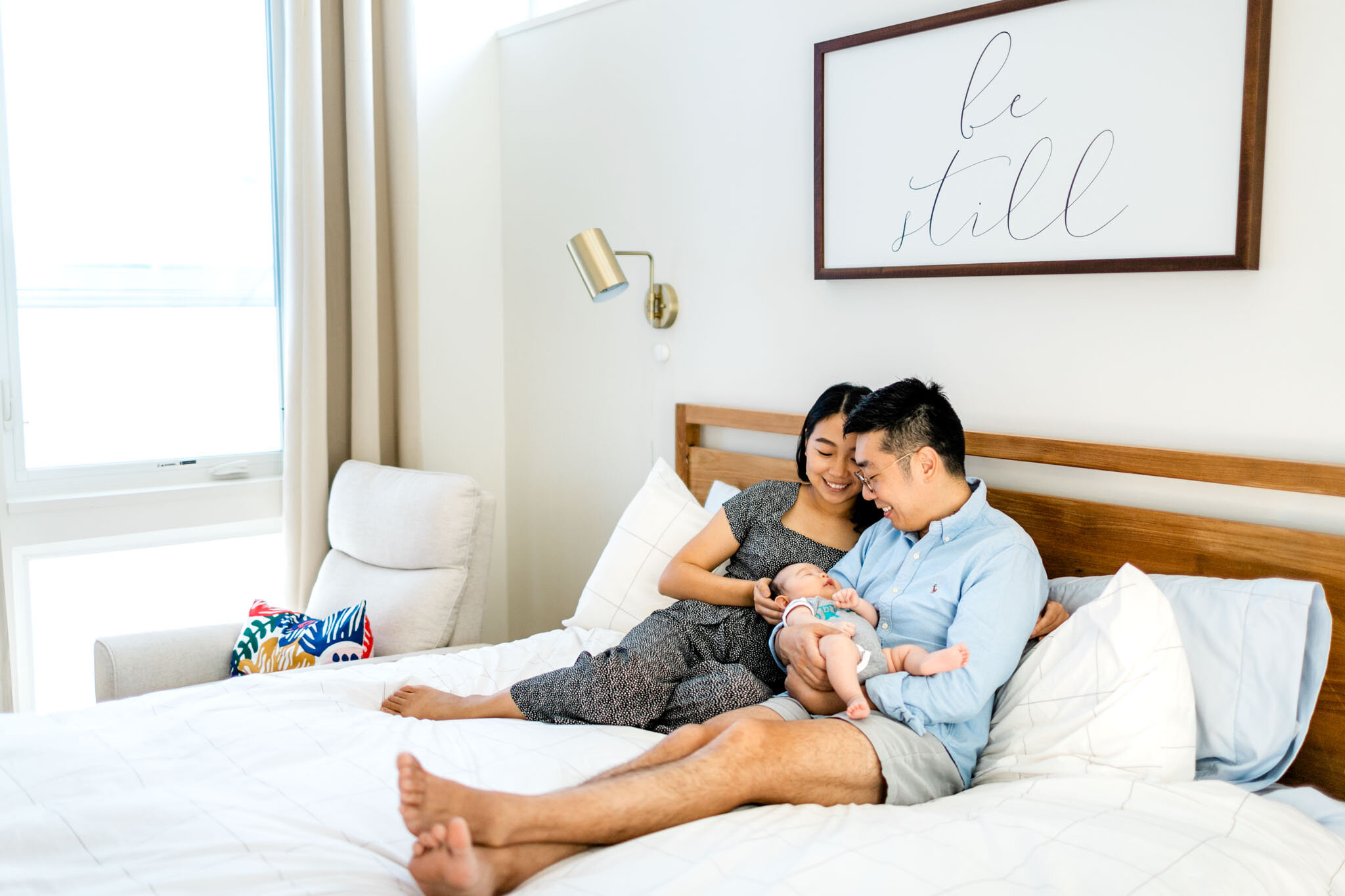 Raleigh Newborn Photographer | By G. Lin Photography | Organic lifestyle newborn photo of parents on bed with baby