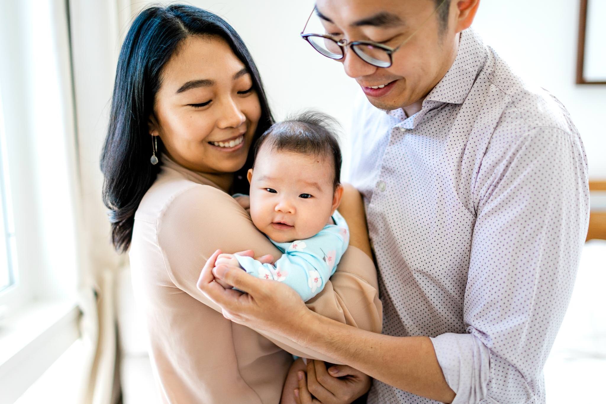 Raleigh Newborn Photographer | By G. Lin Photography | New parents holding baby girl in between them