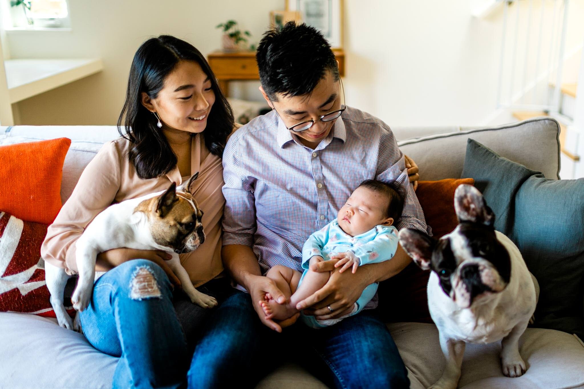 Raleigh Newborn Photographer | By G. Lin Photography | Family sitting together on couch with baby and dogs