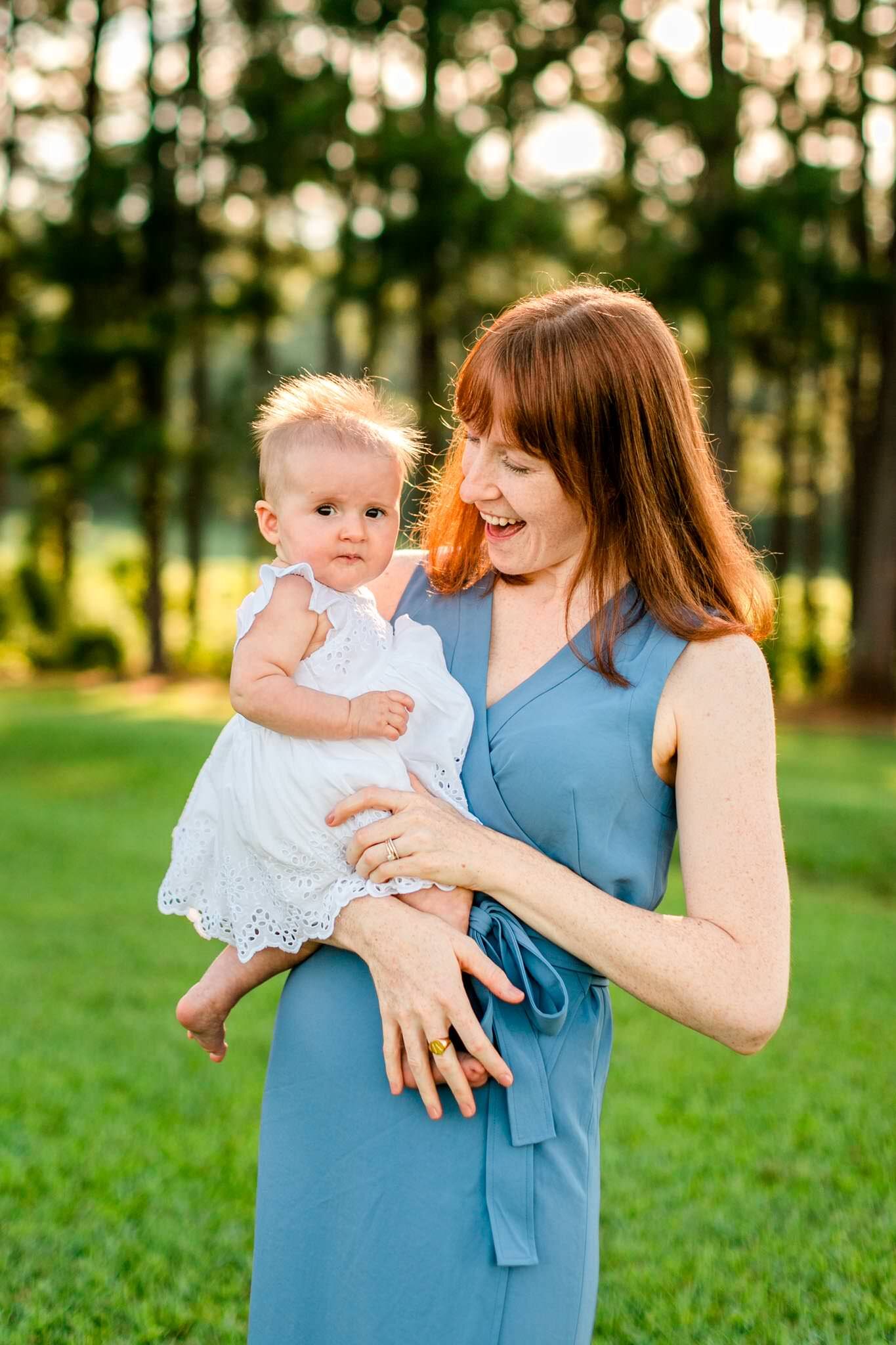 Raleigh Family Photographer | By G. Lin Photography | Dix Park | Candid photo of mother holding baby girl and laughing outside