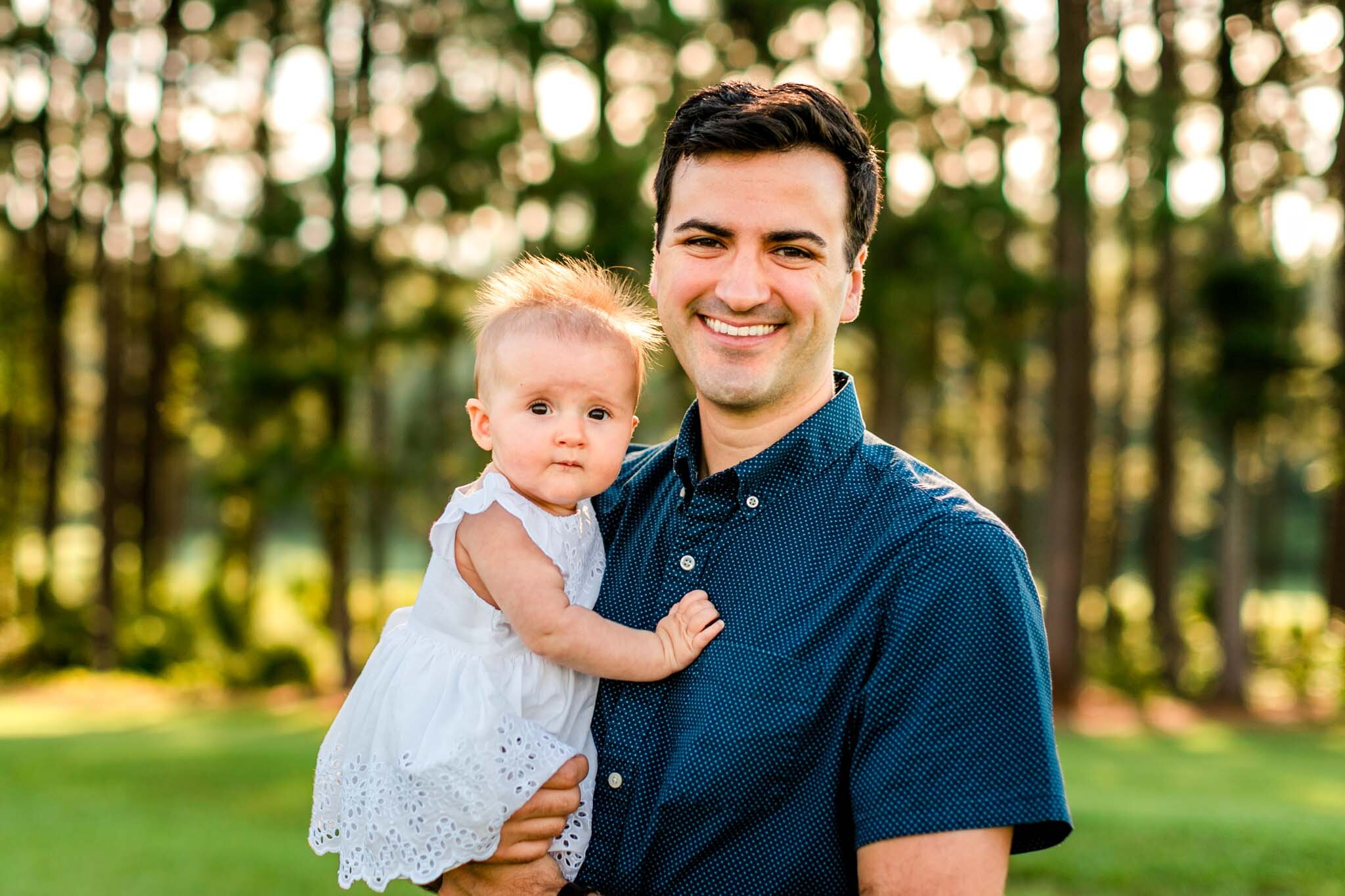 Raleigh Family Photographer | By G. Lin Photography | Dix Park | Father holding baby girl in arms outside
