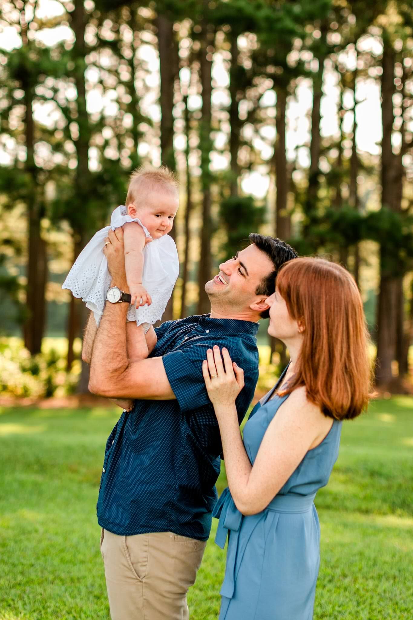 Raleigh Family Photographer | By G. Lin Photography | Dix Park | Family holding baby girl outside