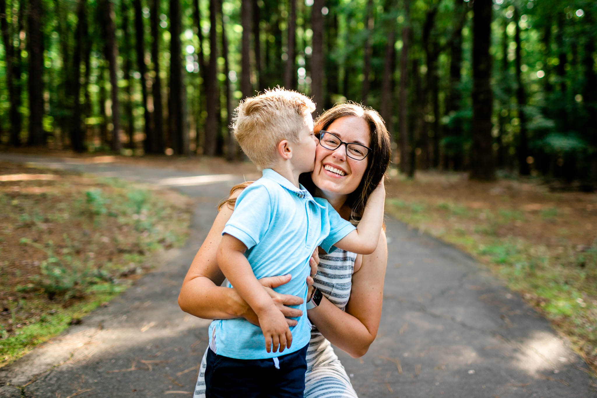 Raleigh Family Photographer | Umstead Park | By G. Lin Photography | Young boy kissing mom on the cheek