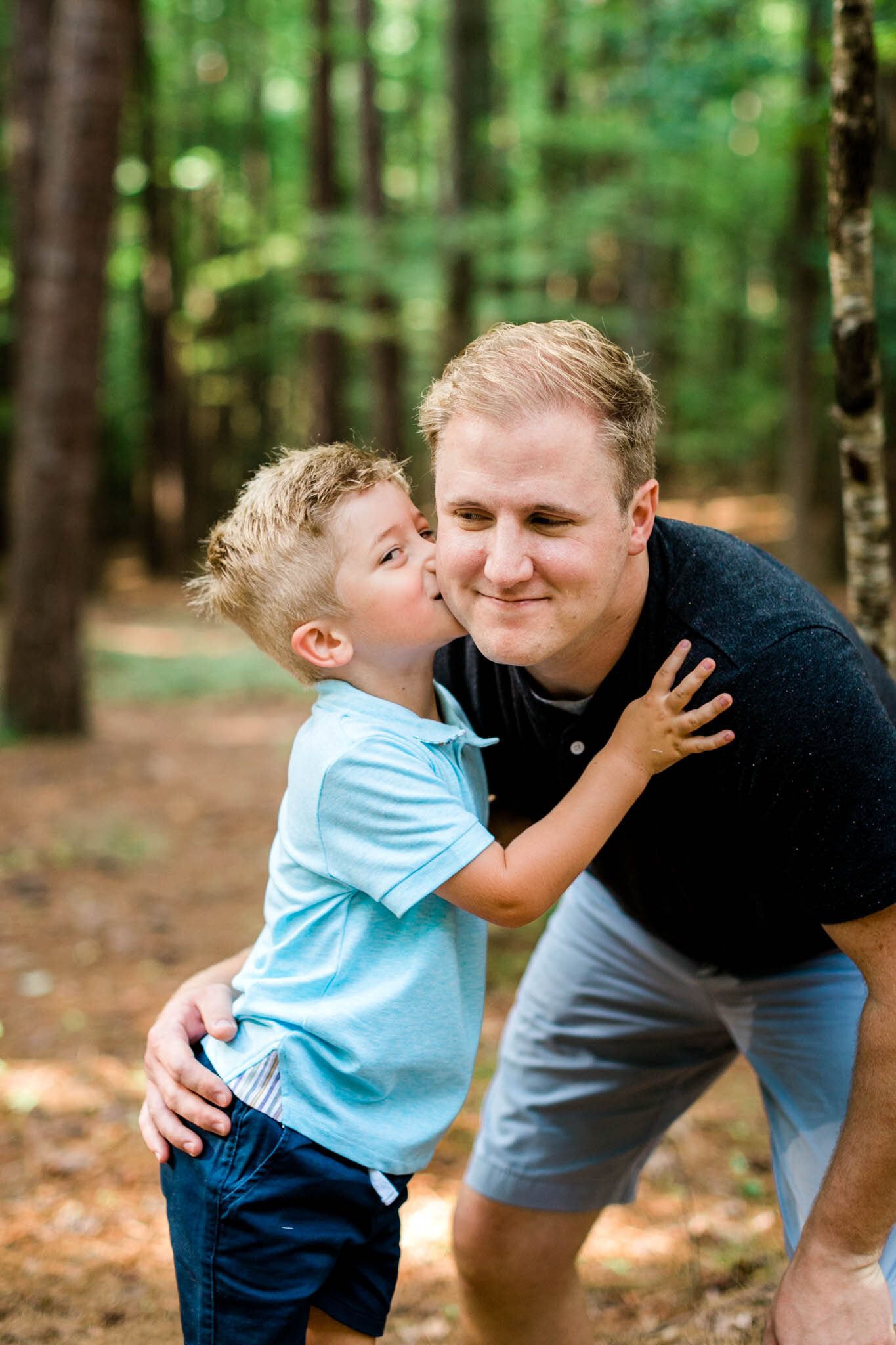 Raleigh Family Photographer | Umstead Park | By G. Lin Photography | Son kissing dad on cheek