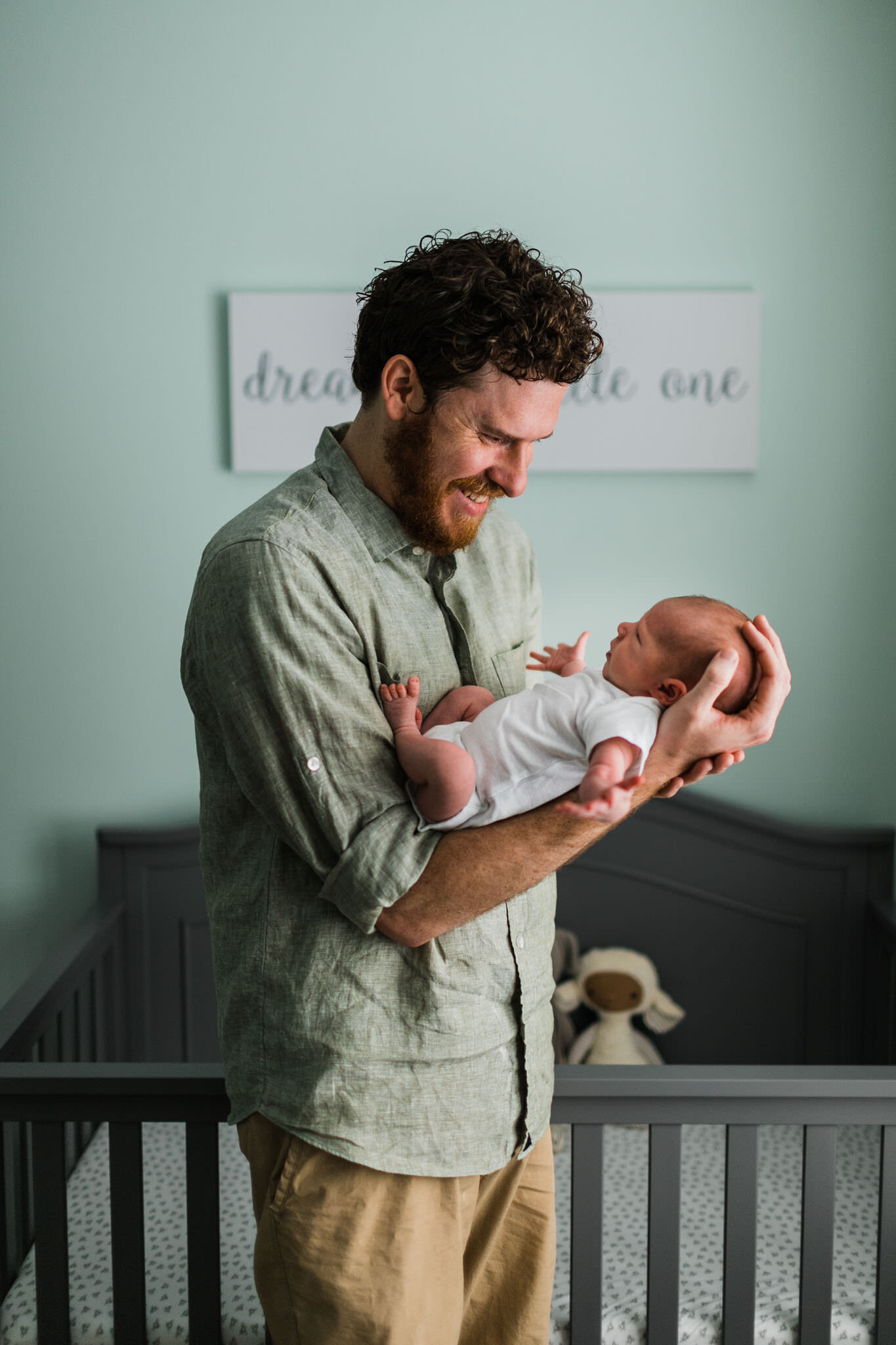 Raleigh Newborn Photographer | By G. Lin Photography | Father holding son while standing in nursery