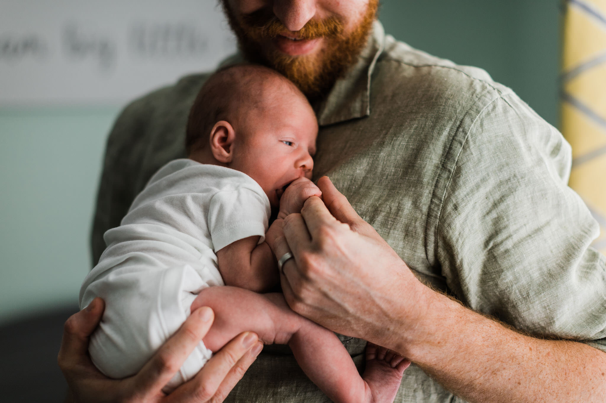 Raleigh Newborn Photographer | By G. Lin Photography | Baby sucking on fingers while being held